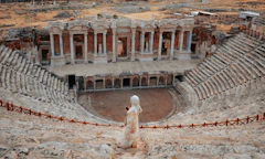 a statue of a woman standing in front of a building