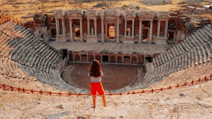 a woman standing in front of an old theater
