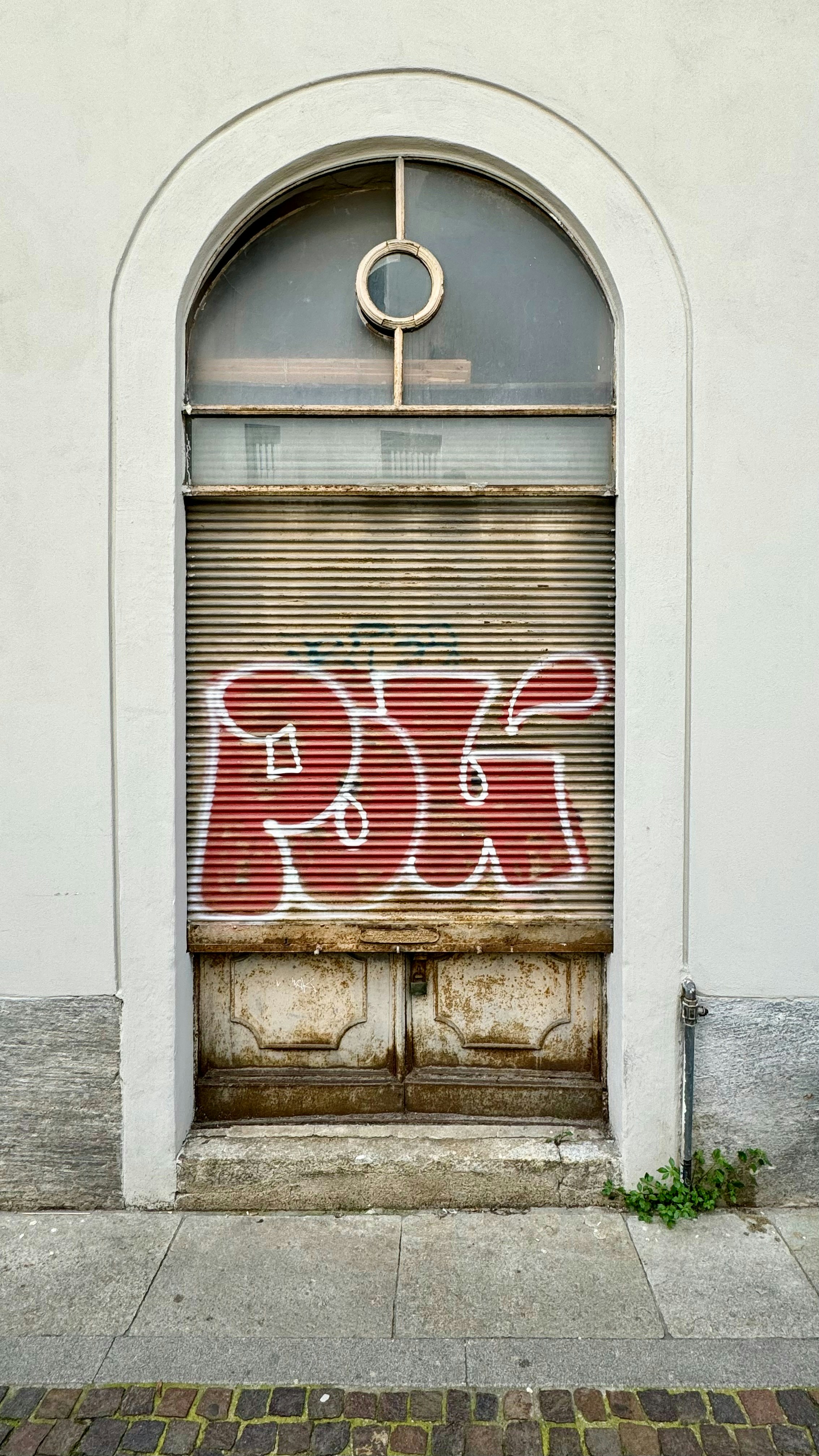 a closed garage door with graffiti on it