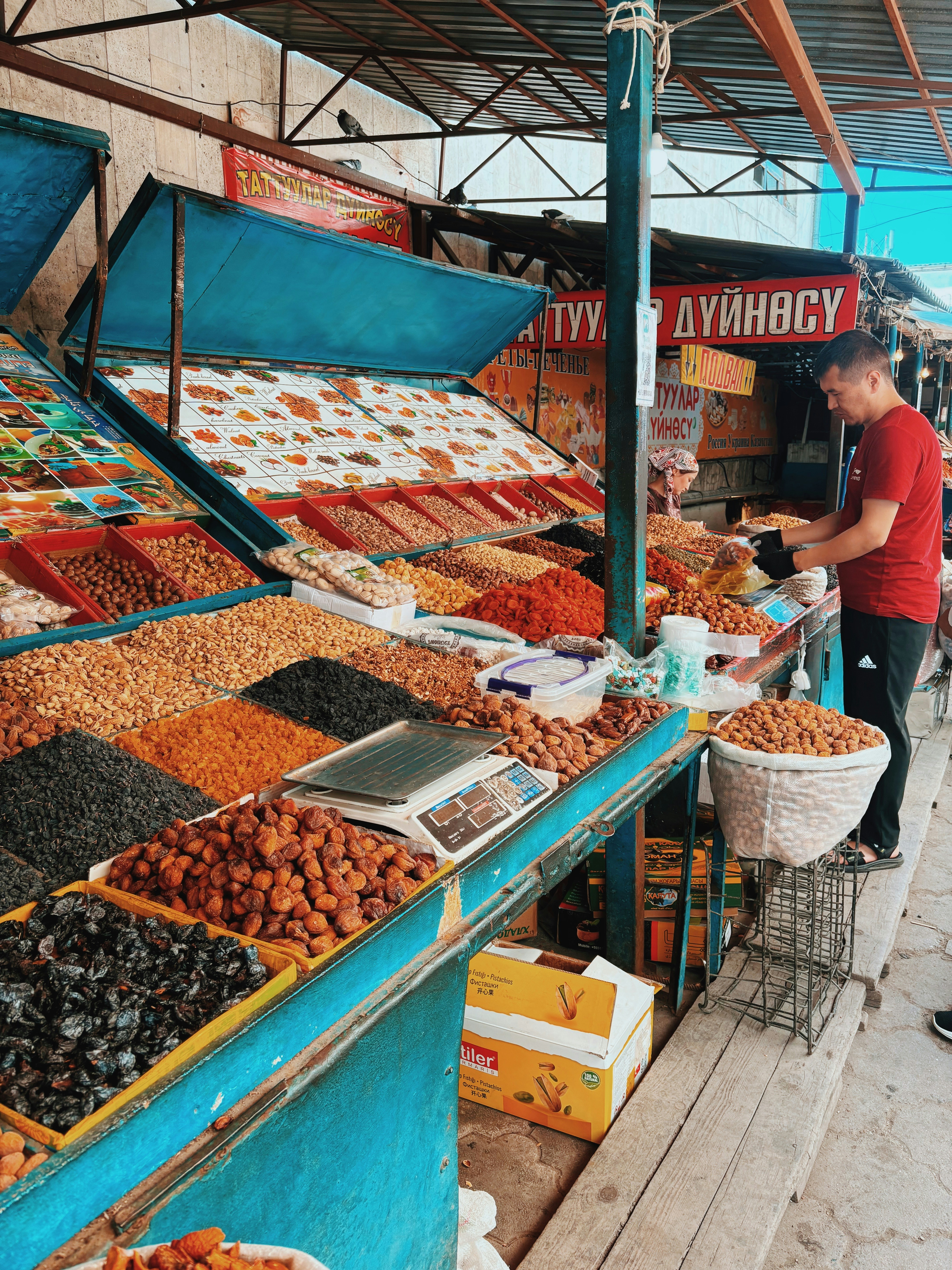 a man standing in front of a store filled with lots of food