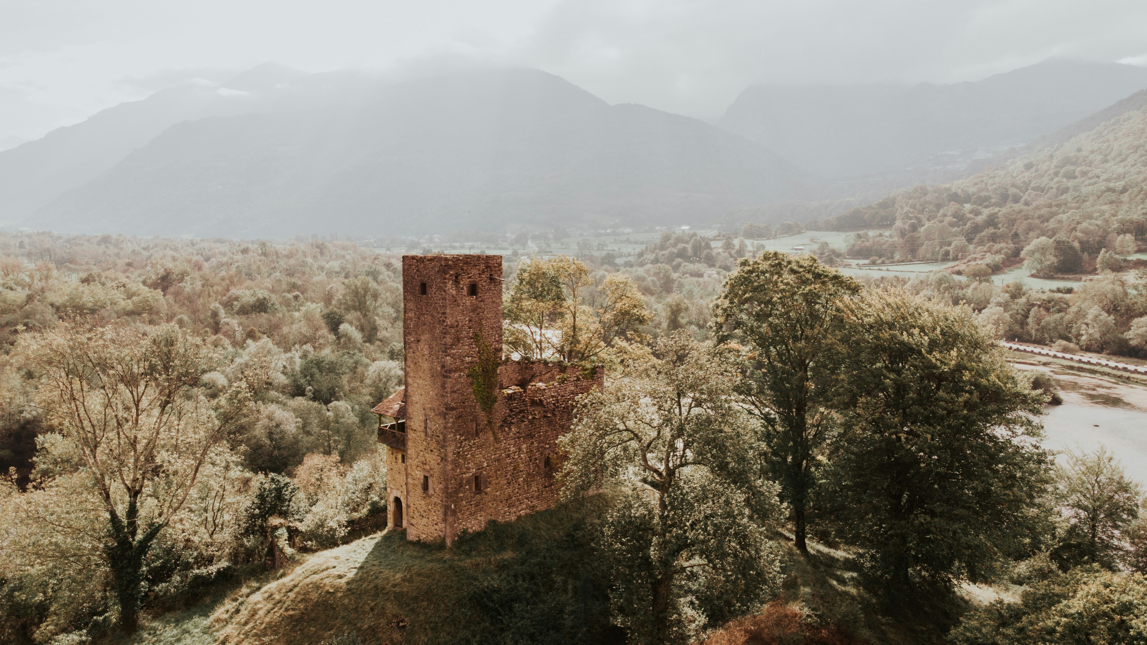 a tall tower sitting on top of a lush green hillside