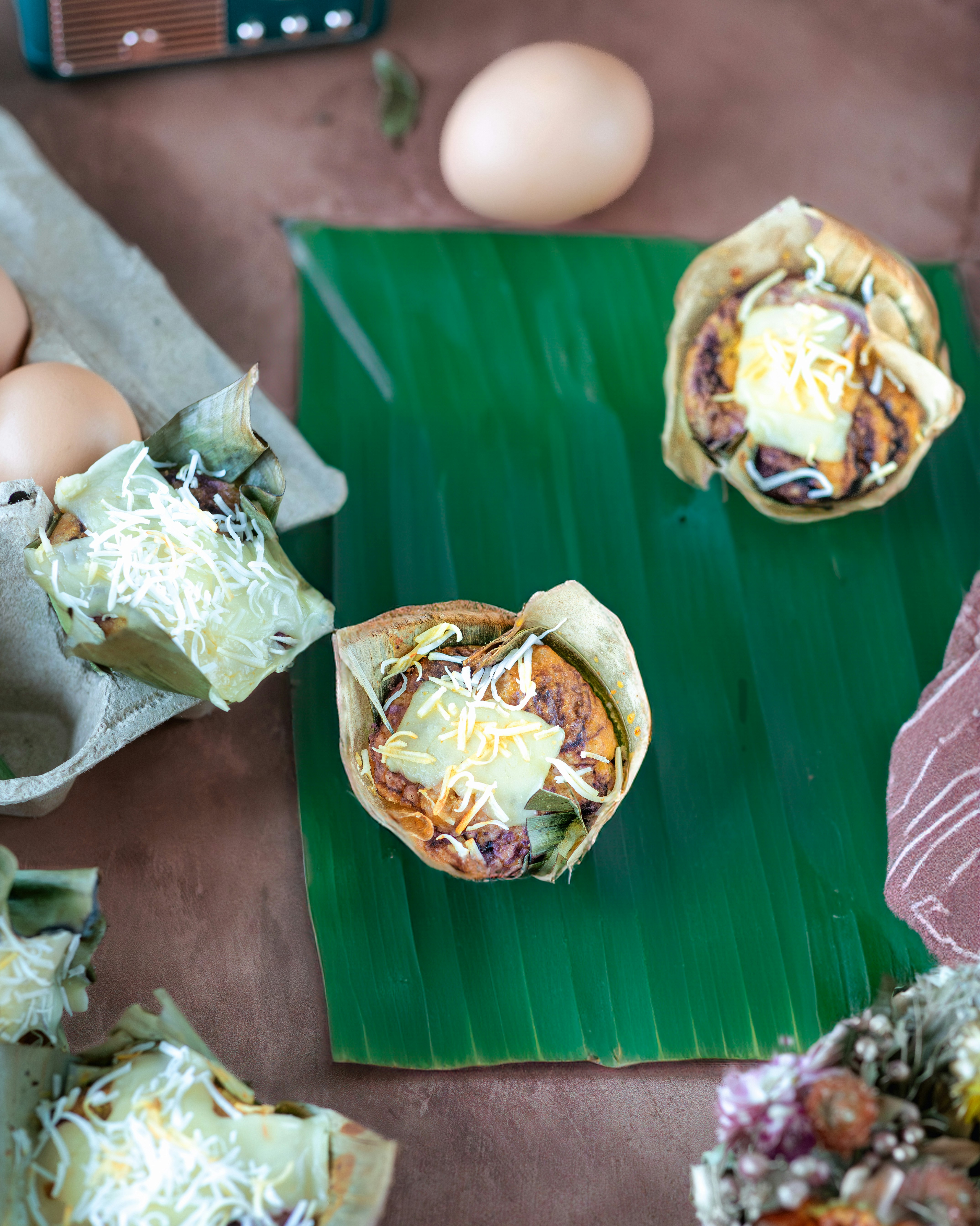 Colorful Filipino kakanin rice cakes including bibingka and puto displayed on banana leaves
