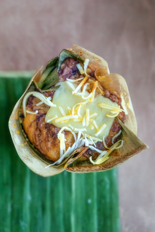 A taco filled with meat and cheese on top of a green plate