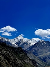 a mountain range with snow capped mountains in the background