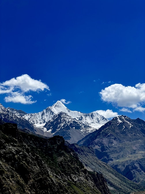 a mountain range with snow capped mountains in the background