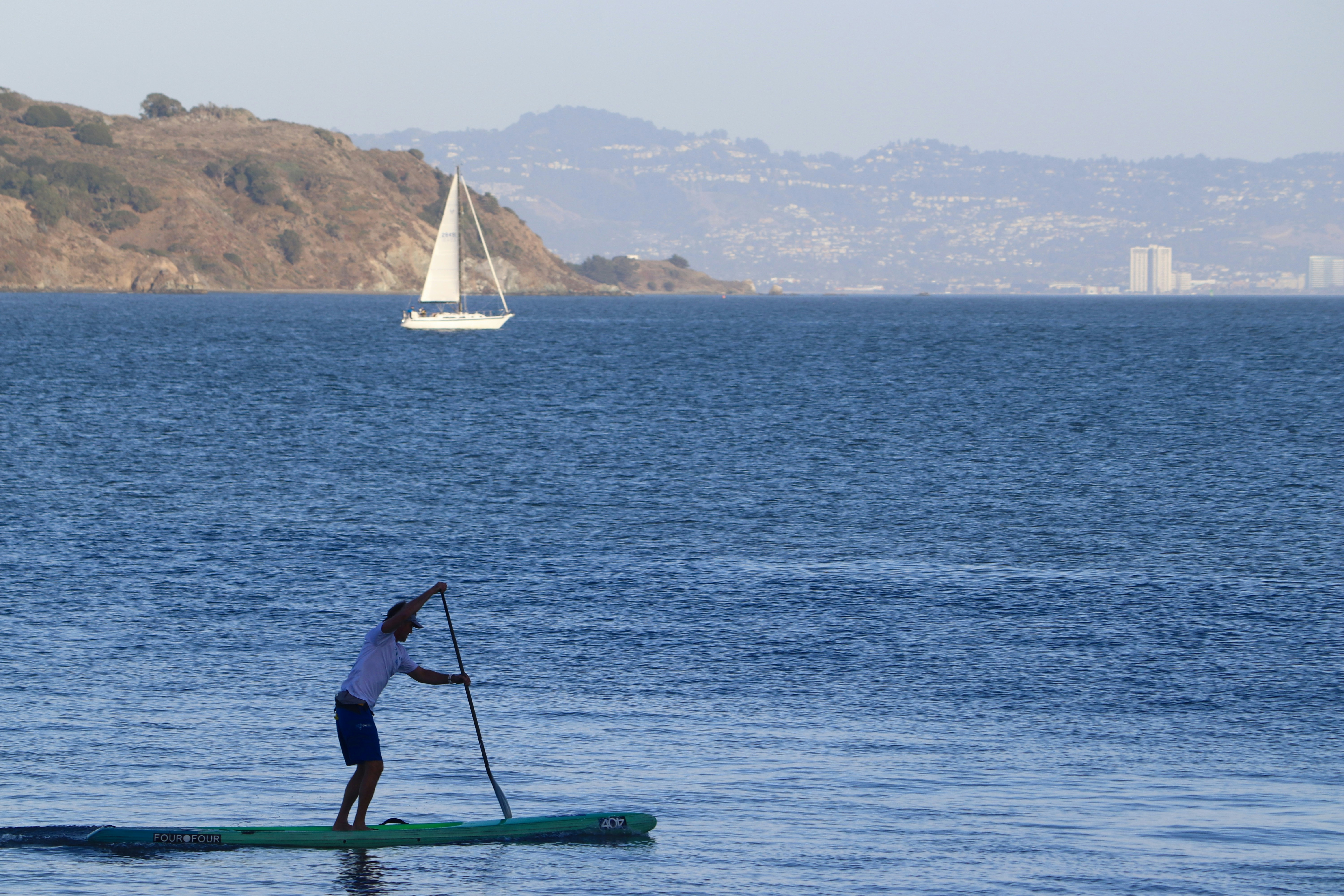a man riding a paddle board on top of a body of water