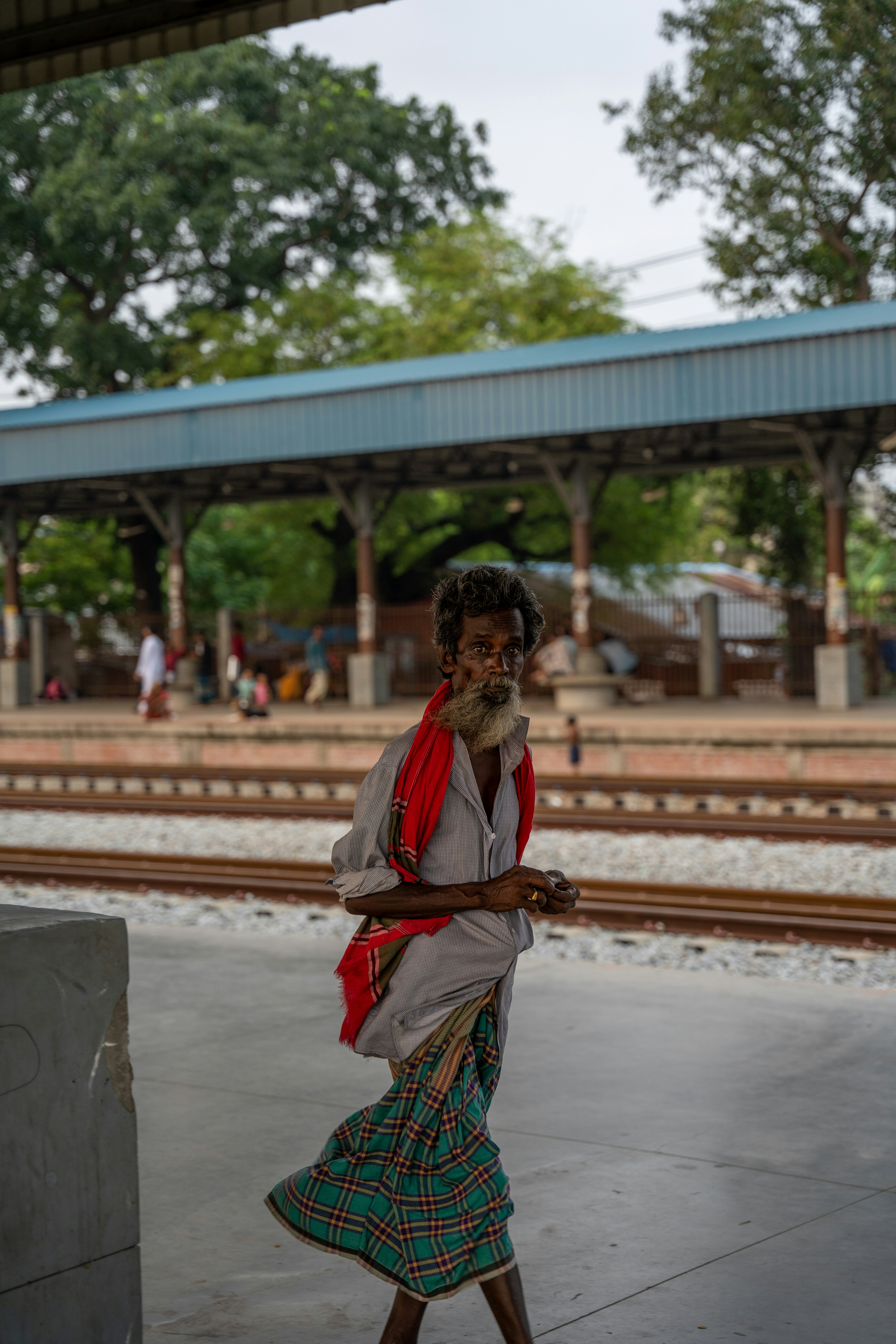 a woman in a skirt is walking near a train station
