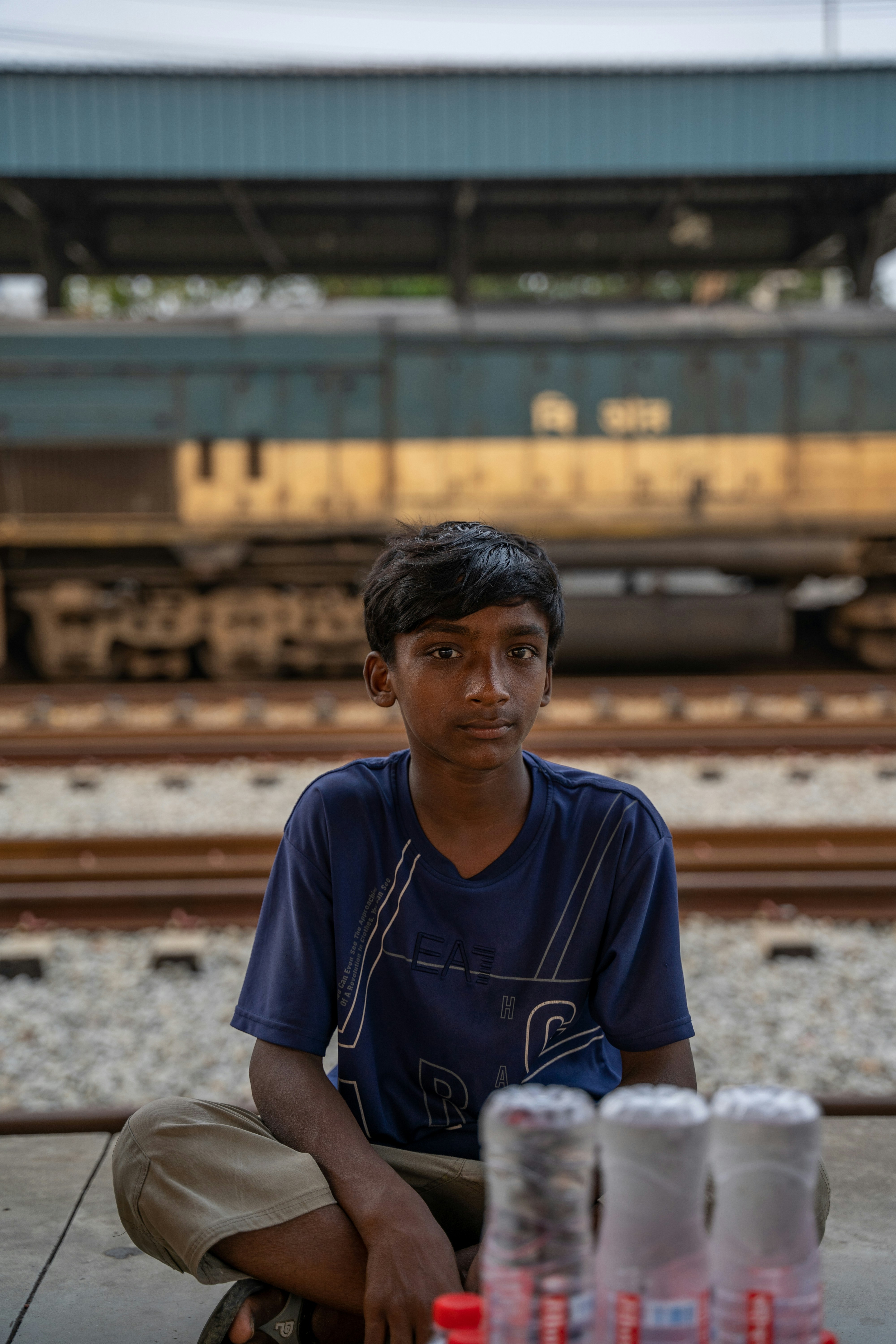 a man sitting on the ground next to a train