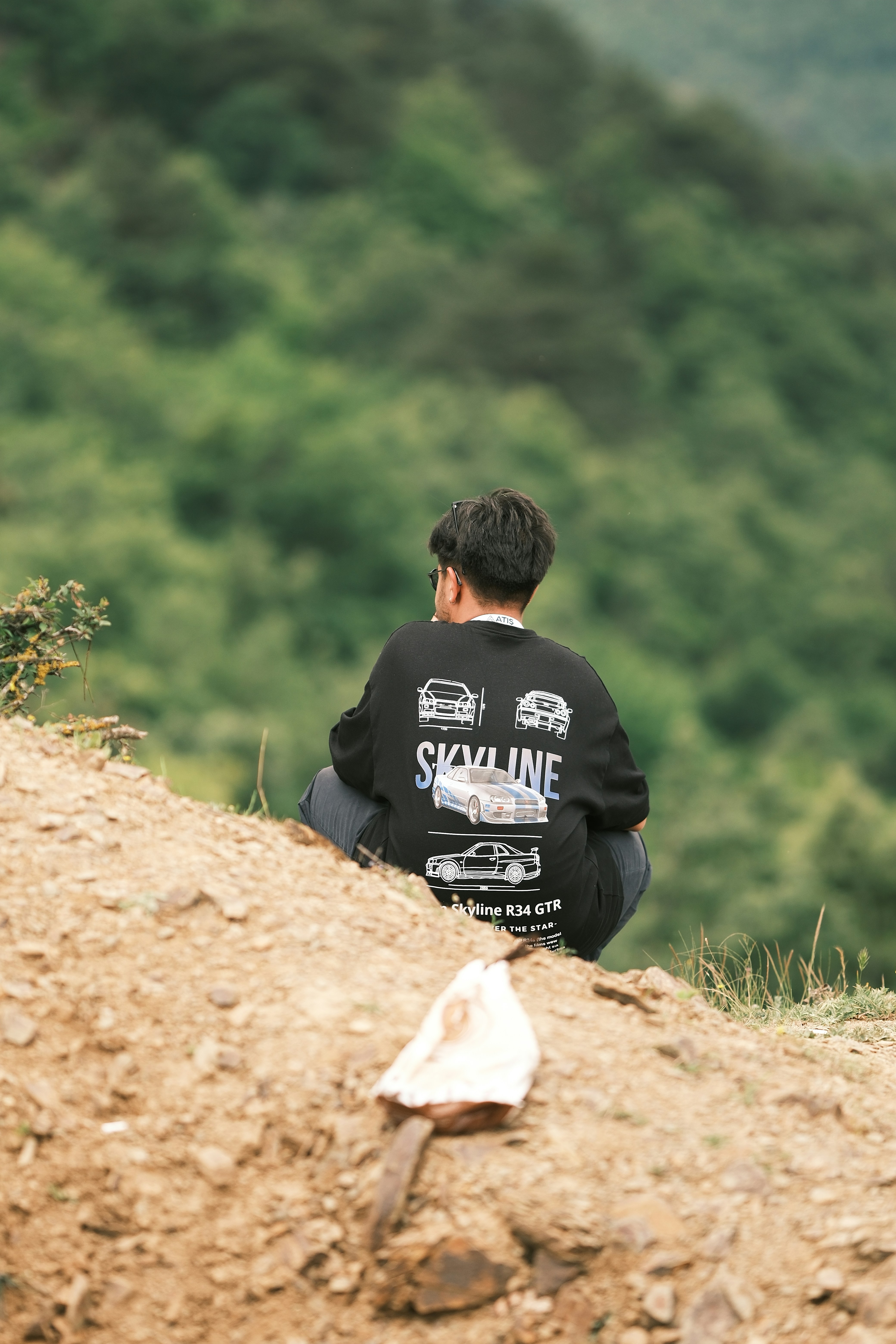 A man sitting on top of a dirt hill
