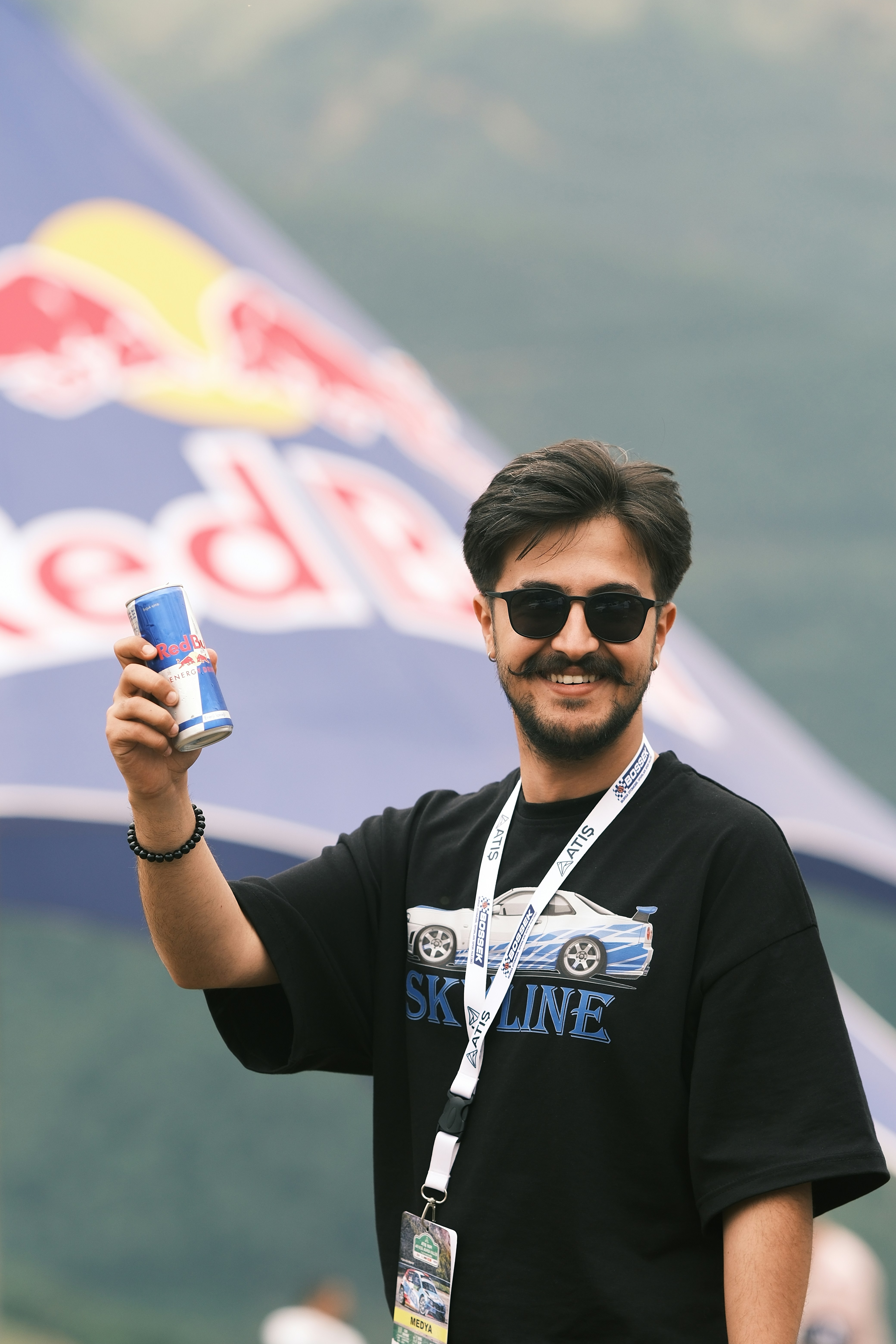 Un homme en chemise noire tenant un téléphone portable