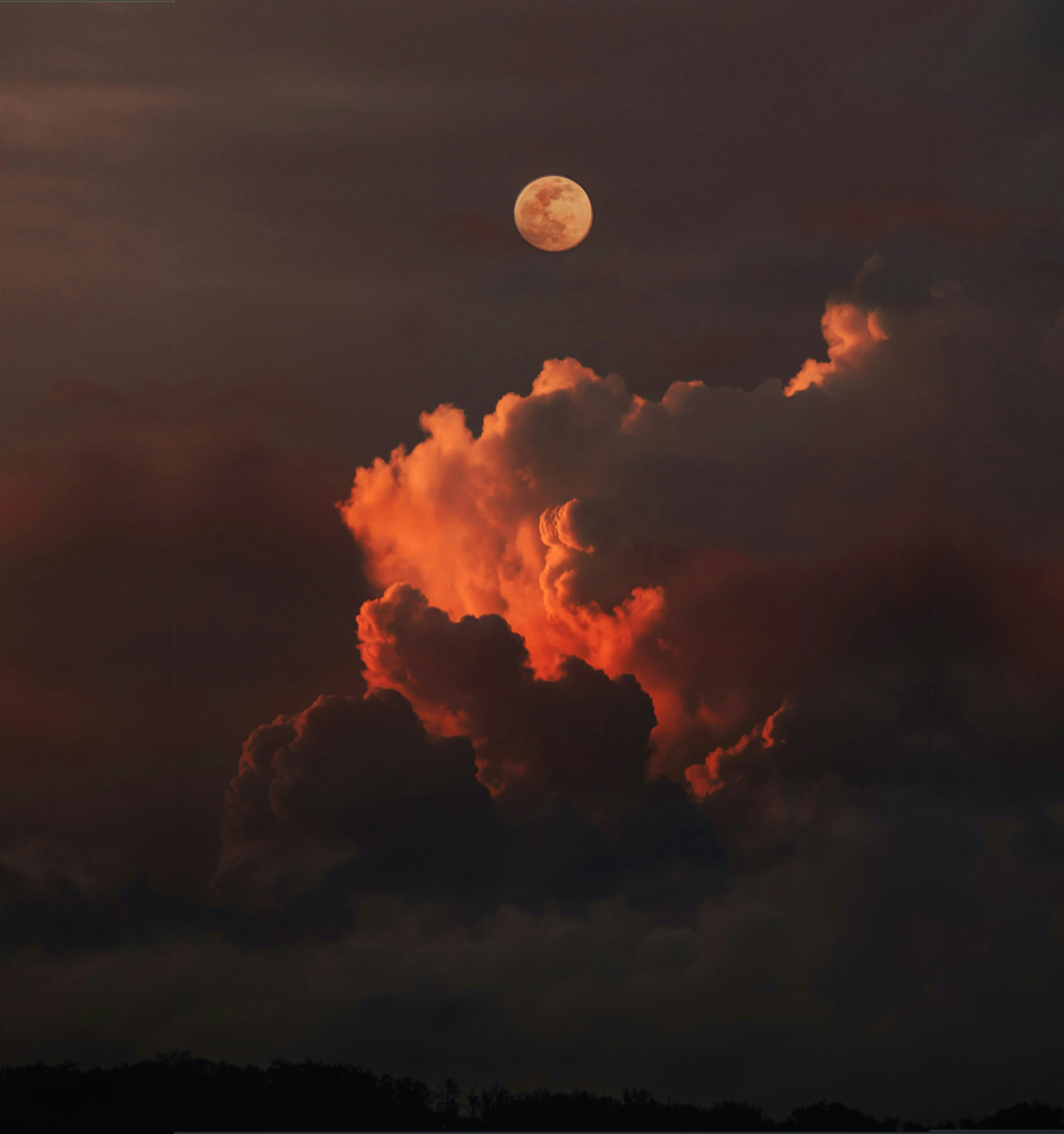 a full moon is seen through the clouds