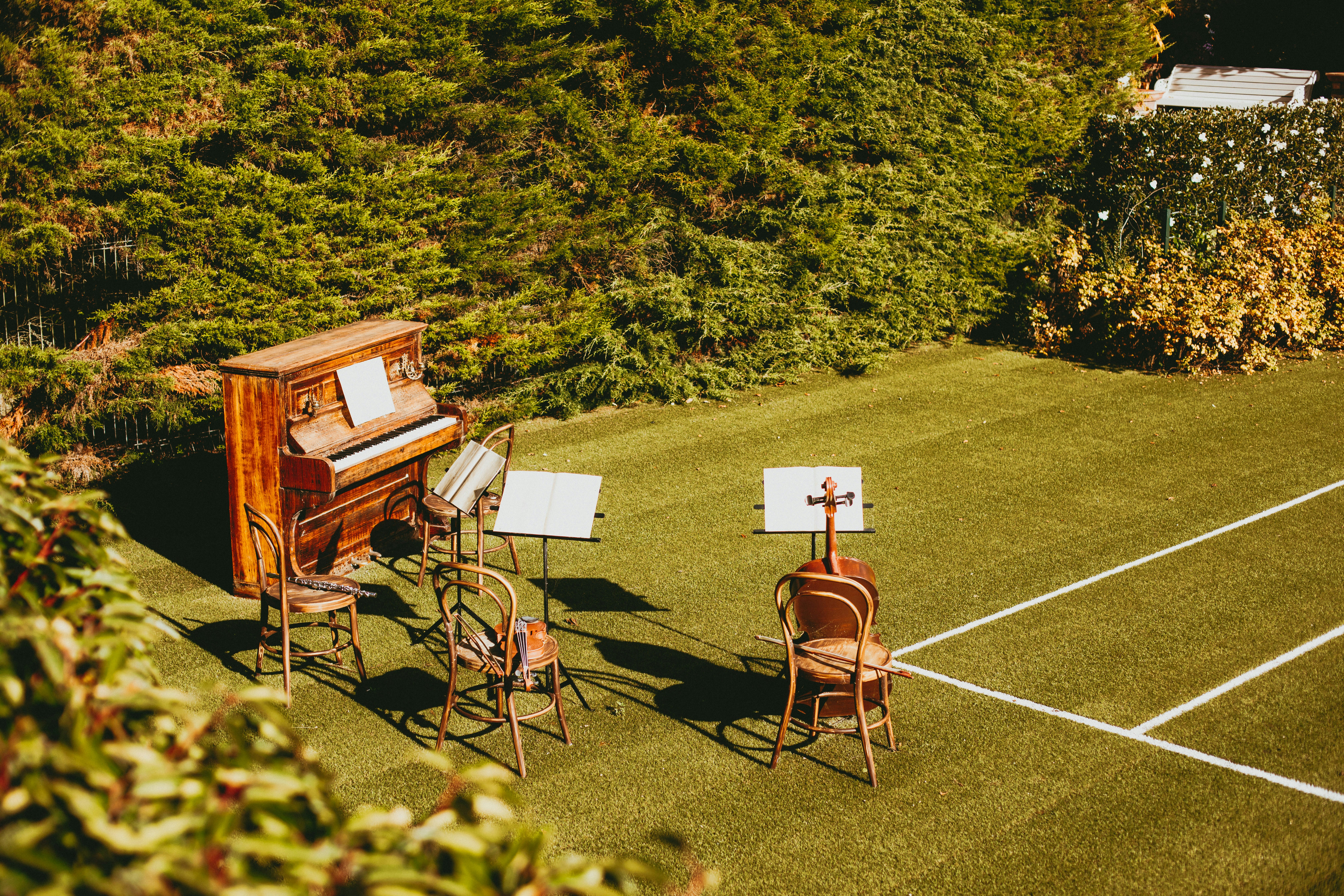 A group of chairs and a piano on a tennis court