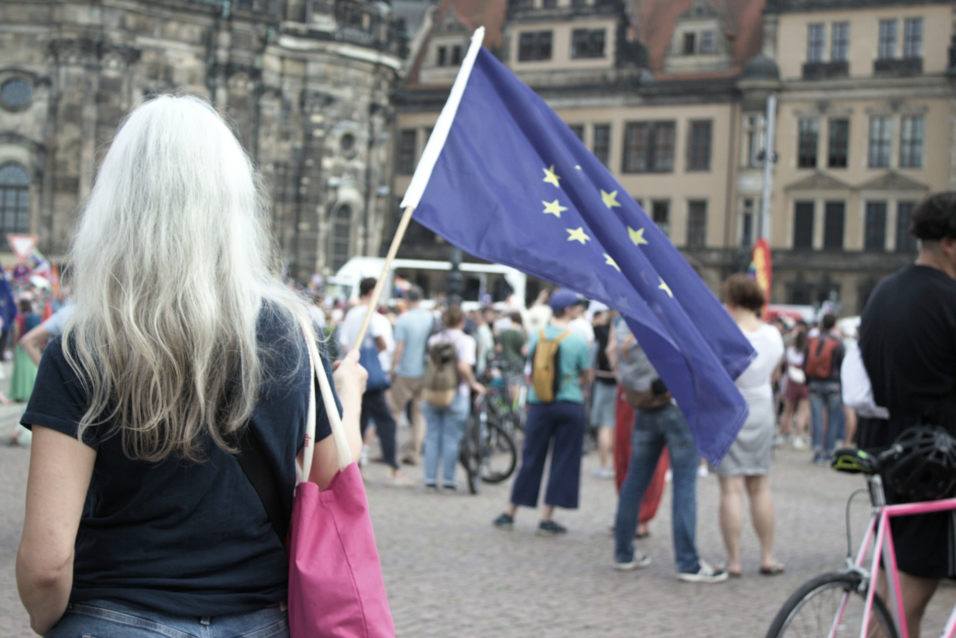 A woman walking down a street holding a flag