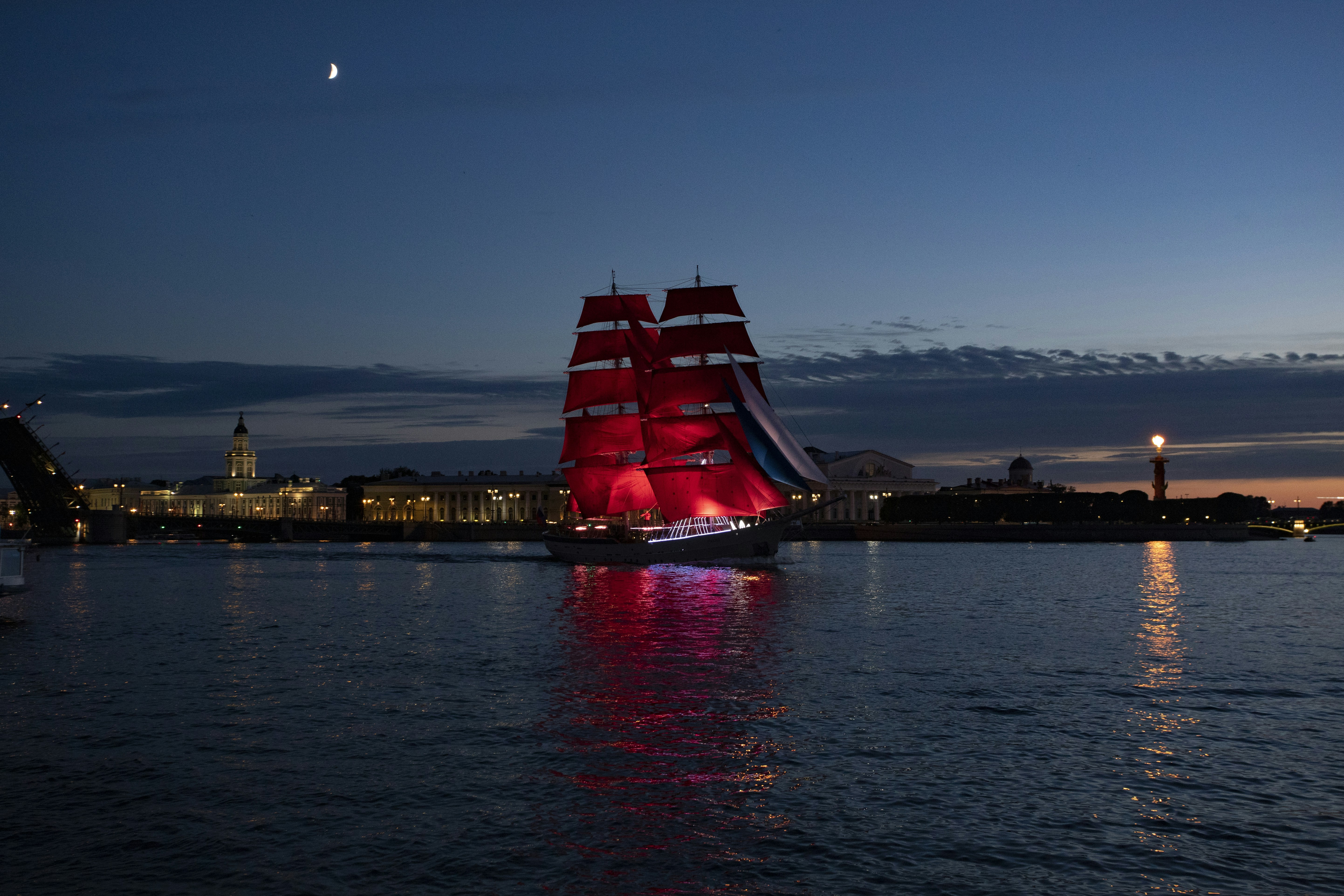 A large red boat sailing on top of a body of water