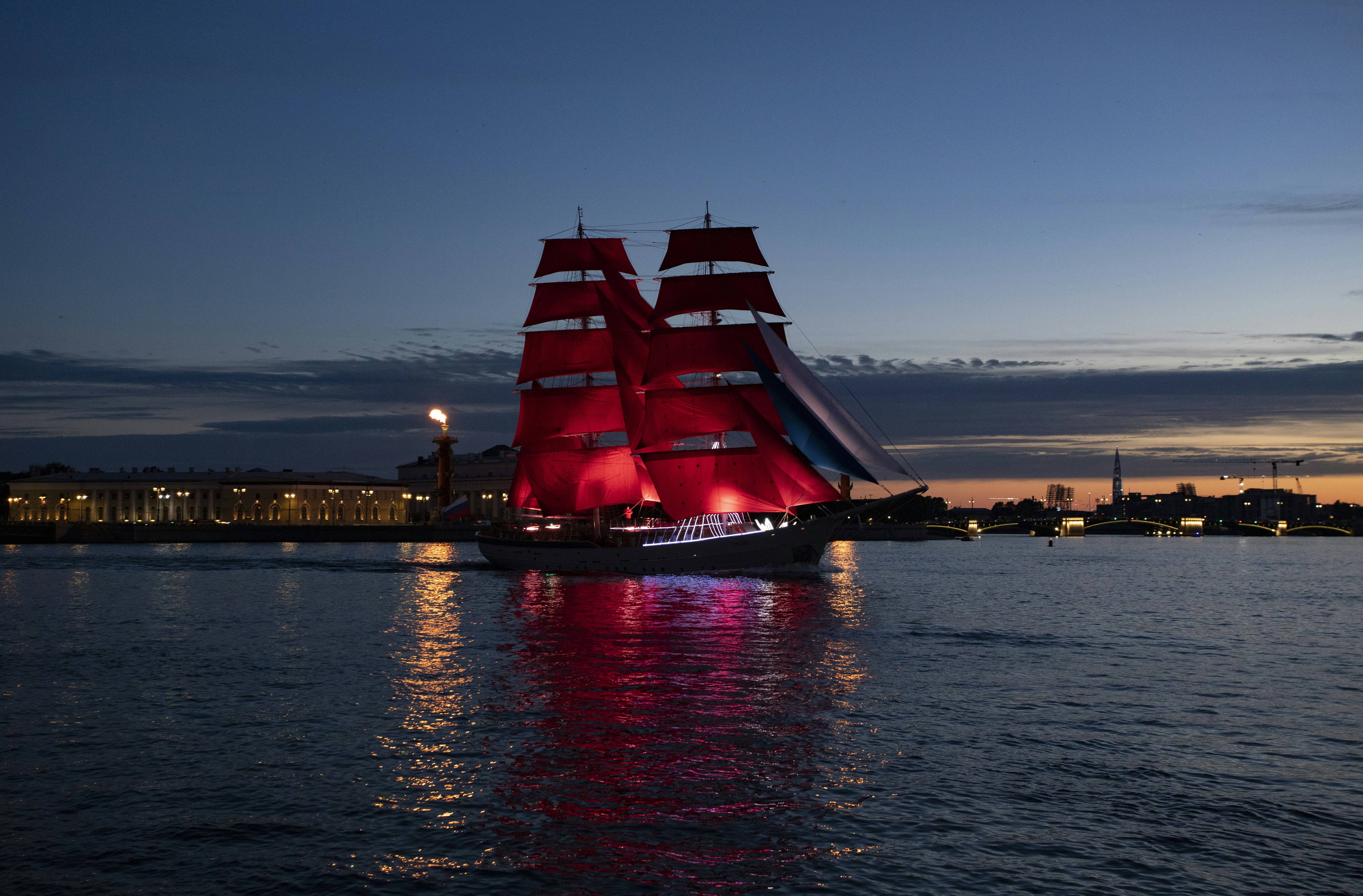 A large red ship sailing on top of a body of water