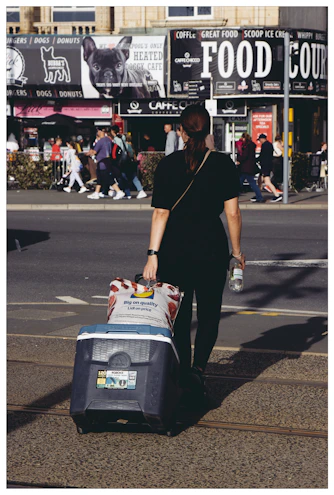 A woman pulling a suitcase down the street