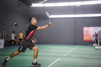 A man holding a tennis racquet on top of a tennis court