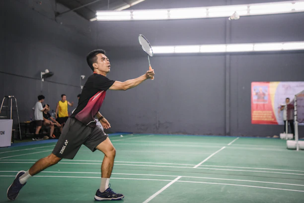 A man holding a tennis racquet on top of a tennis court