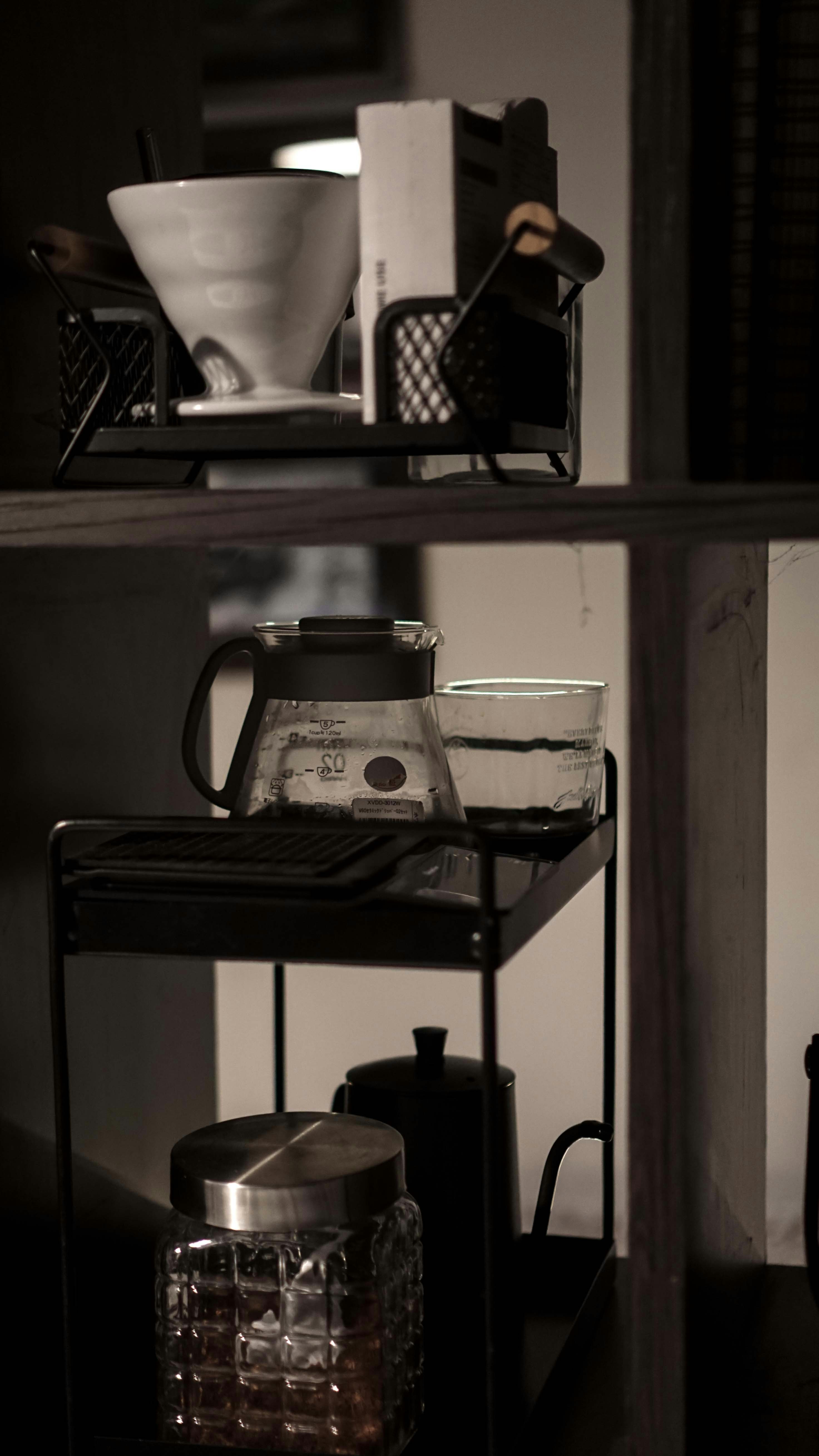 A kitchen shelf with a coffee pot on top of it