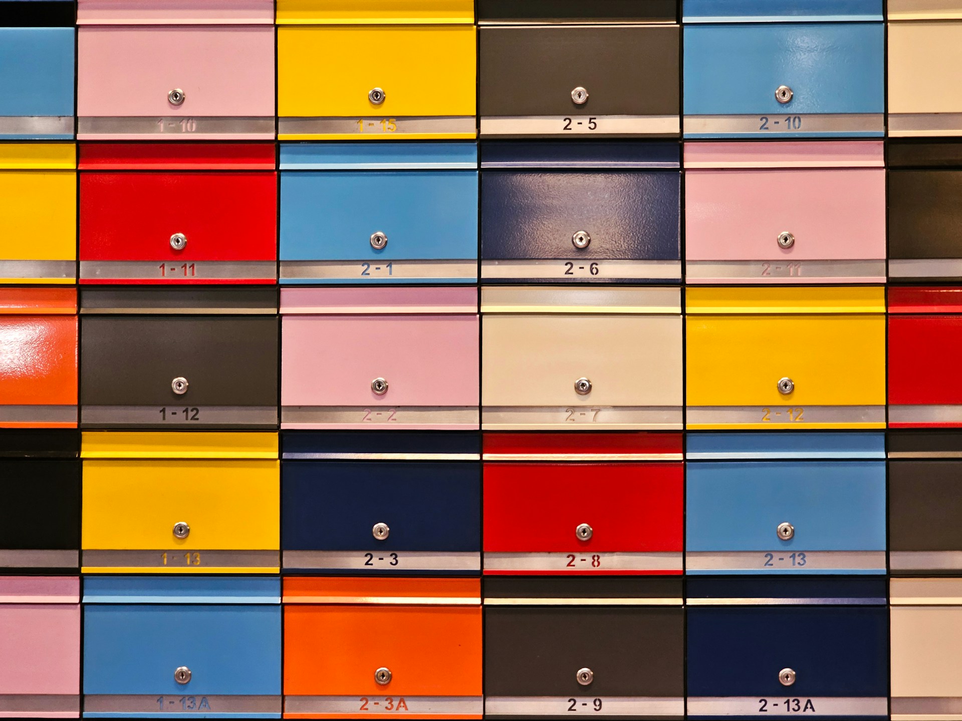 A wall of many different colored drawers
