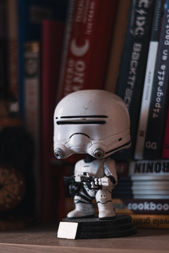 A star wars figurine sitting on a book shelf