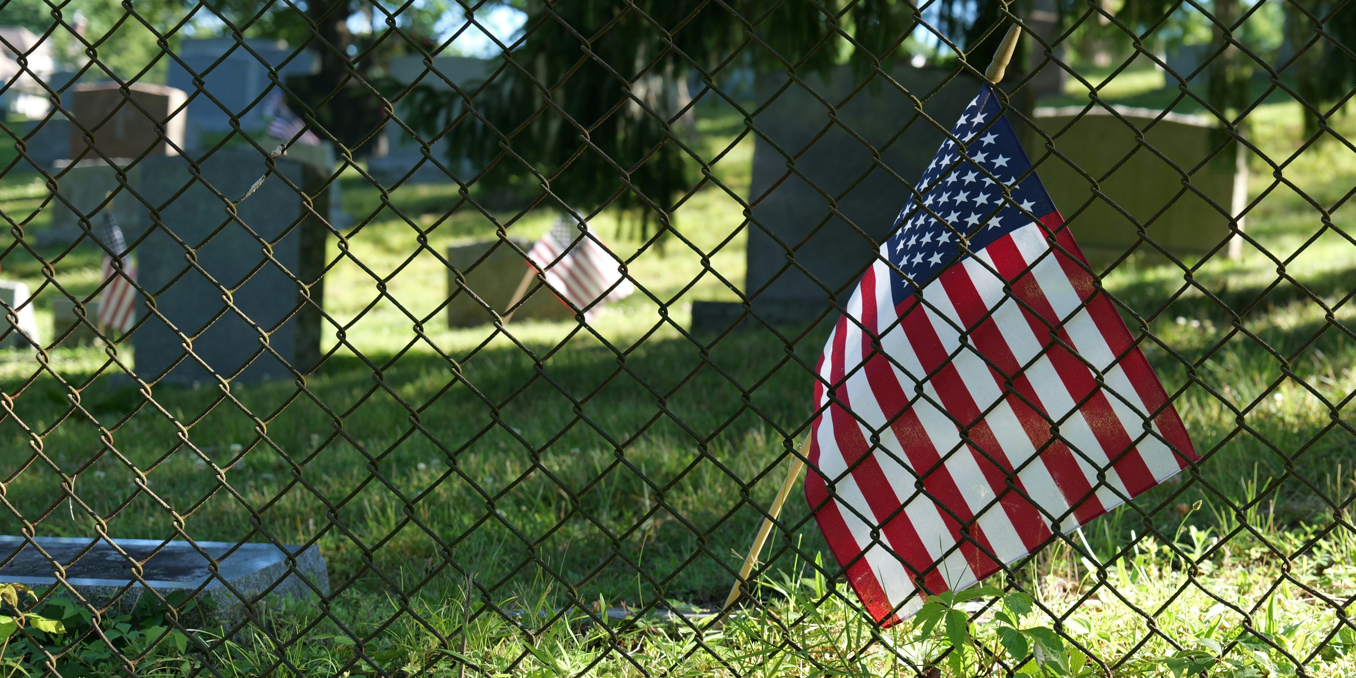 An american flag hanging on a chain link fence