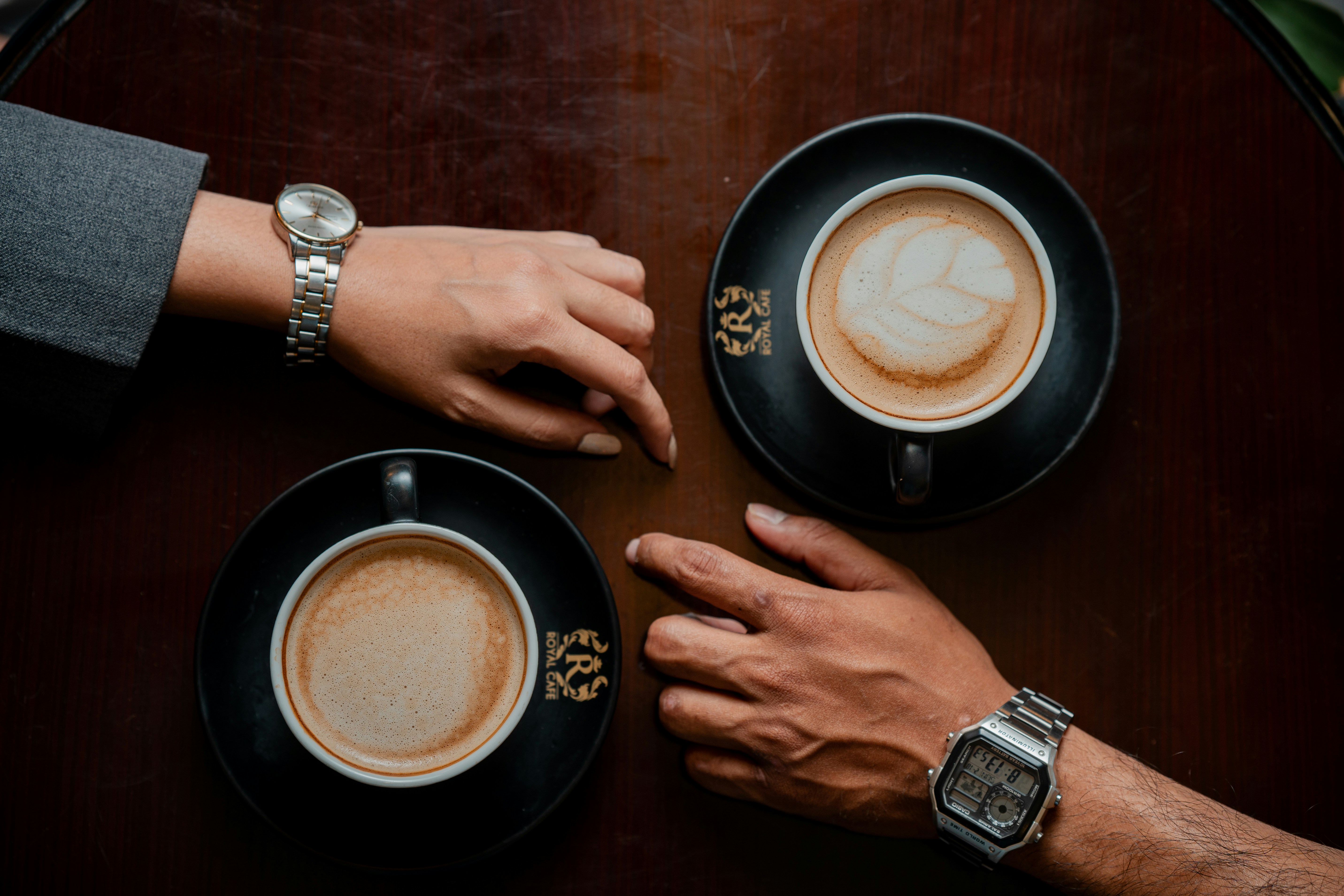 A couple of people sitting at a table with cups of coffee