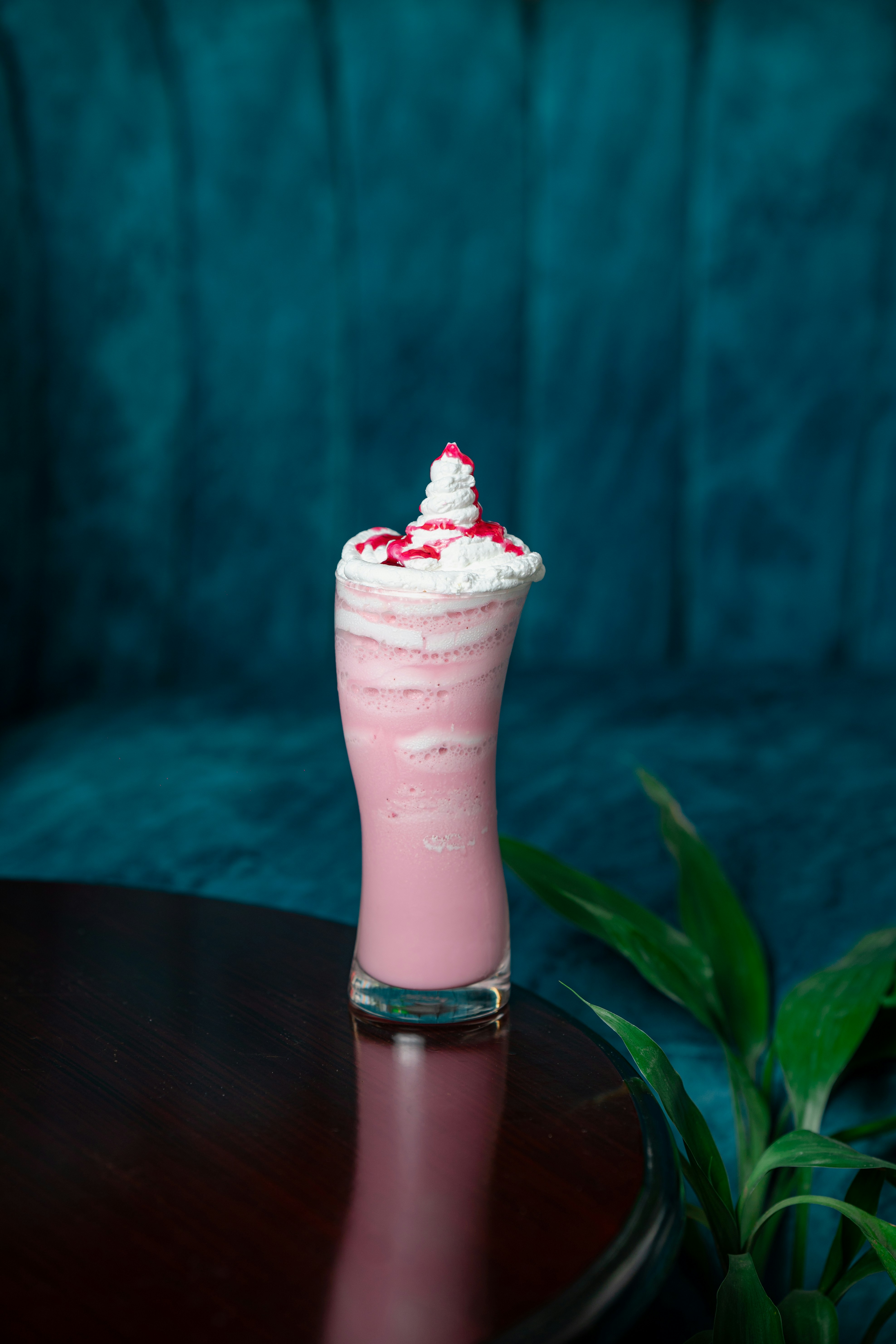 A pink drink sitting on top of a wooden table