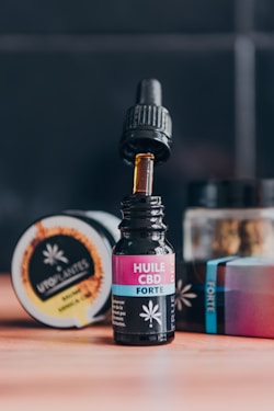 A bottle of cbd sitting on a table next to a container of cbd