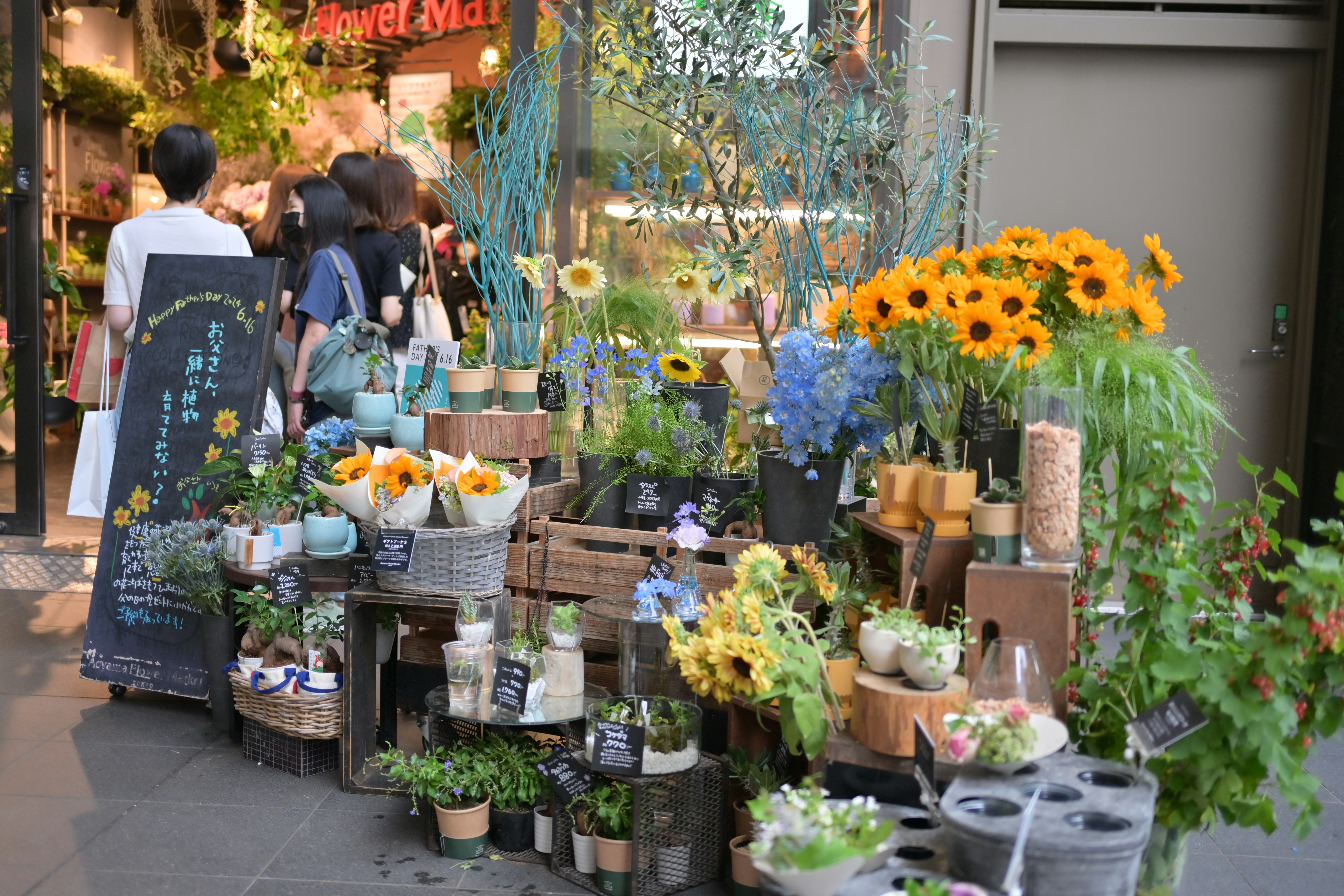 Un grupo de personas parado afuera de una floristería