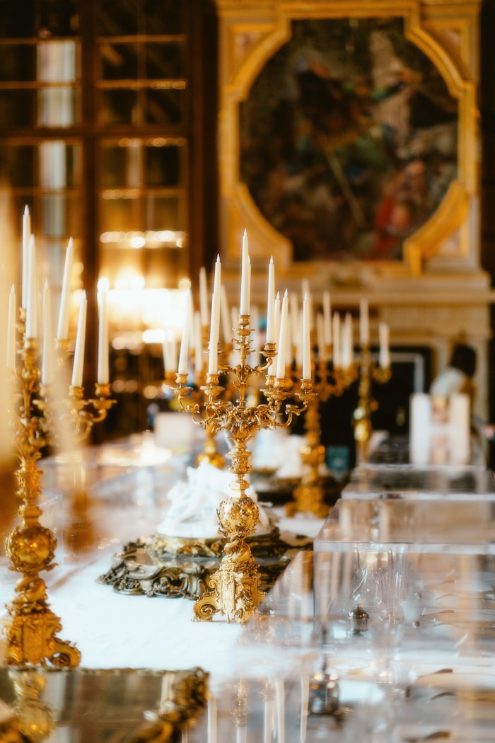 Candelabro dorado con velas encendidas sobre una mesa elegante en un salón opulento