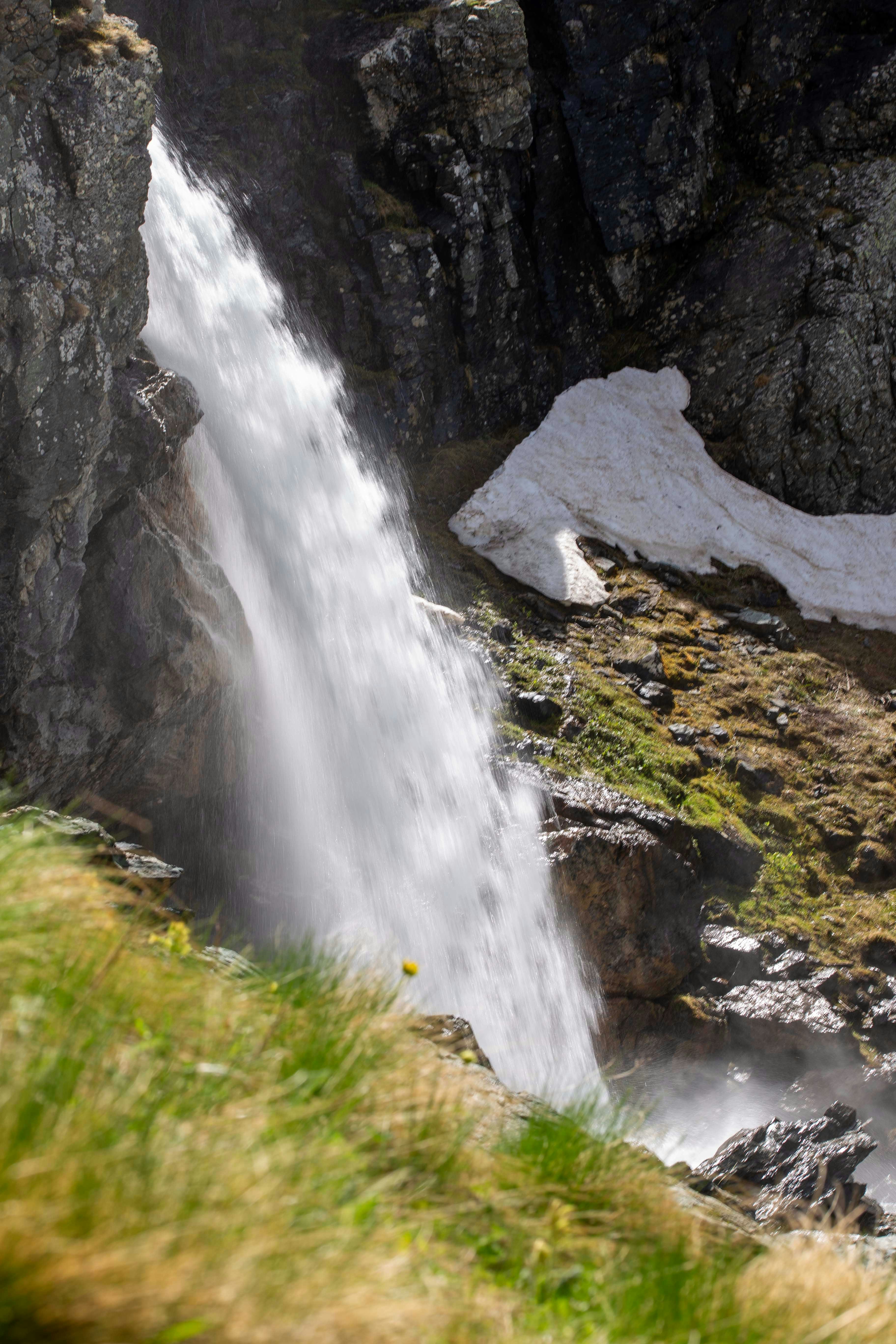 A large waterfall is coming out of the side of a mountain