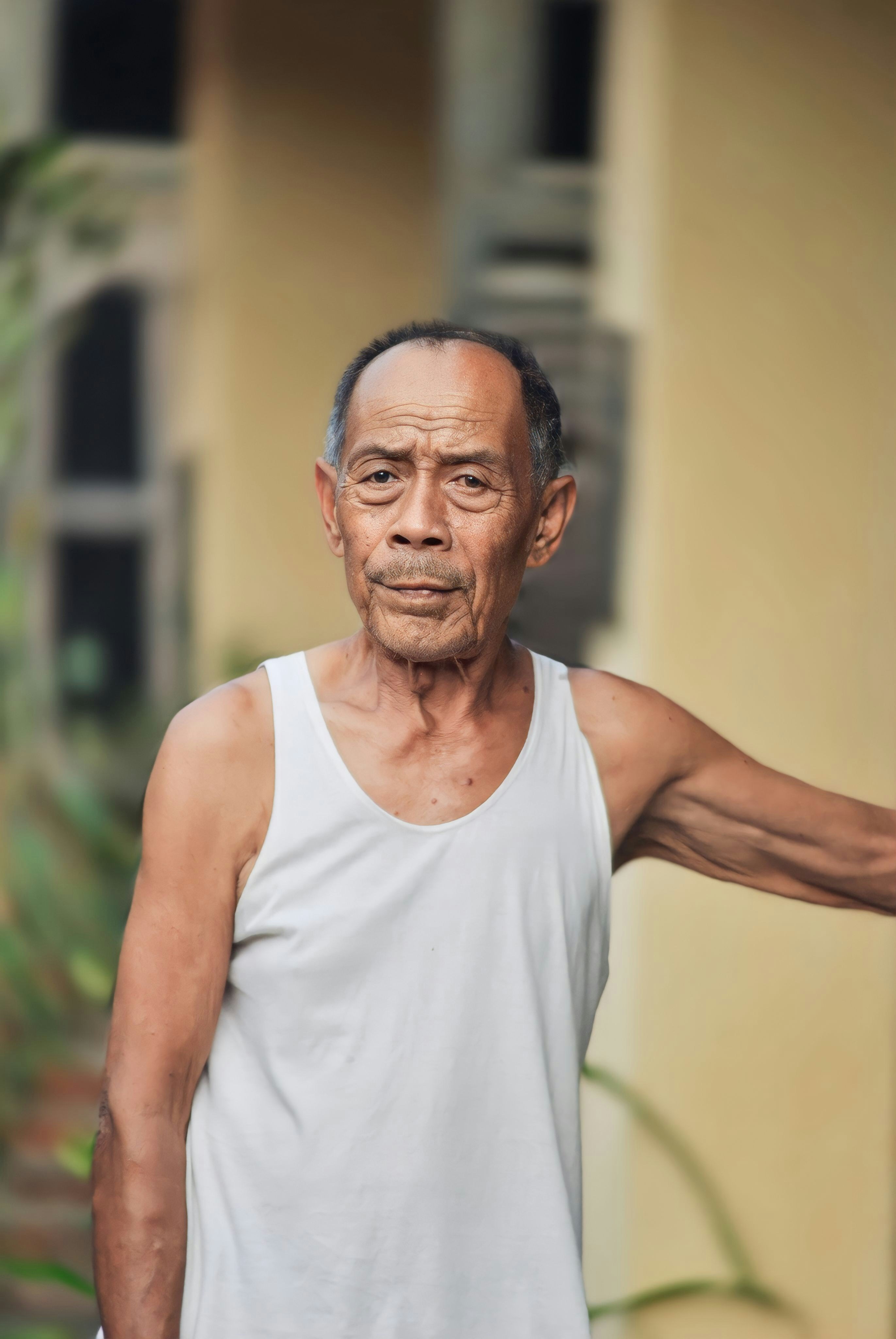 A man in a tank top holding a frisbee