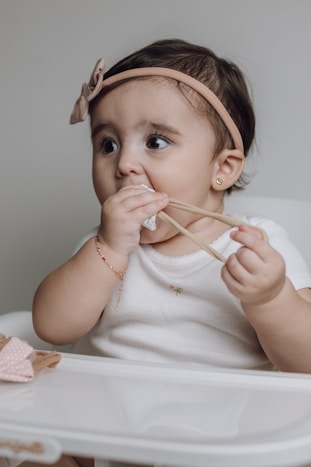 A baby sitting in a high chair eating food