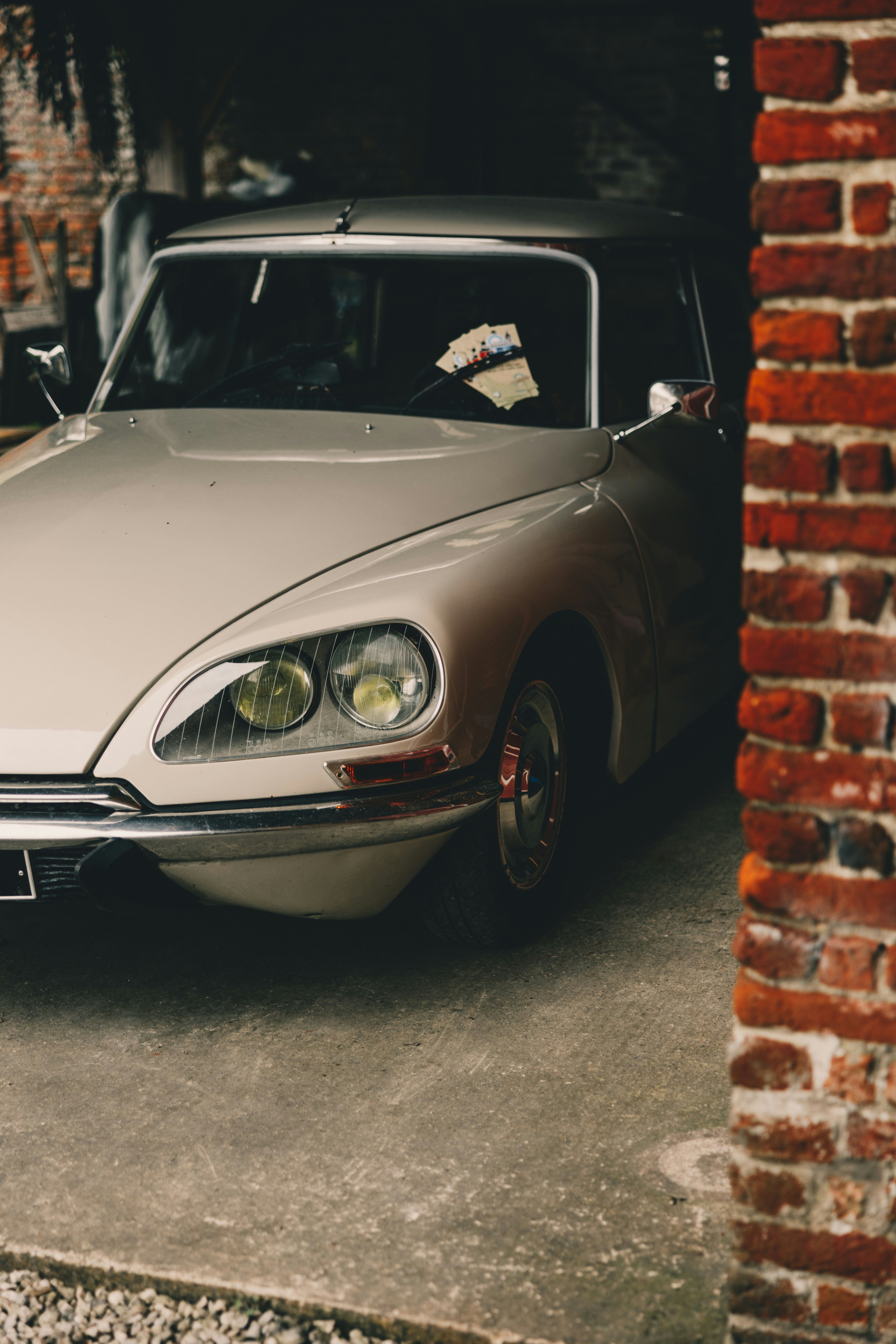 A car parked in a garage next to a brick wall