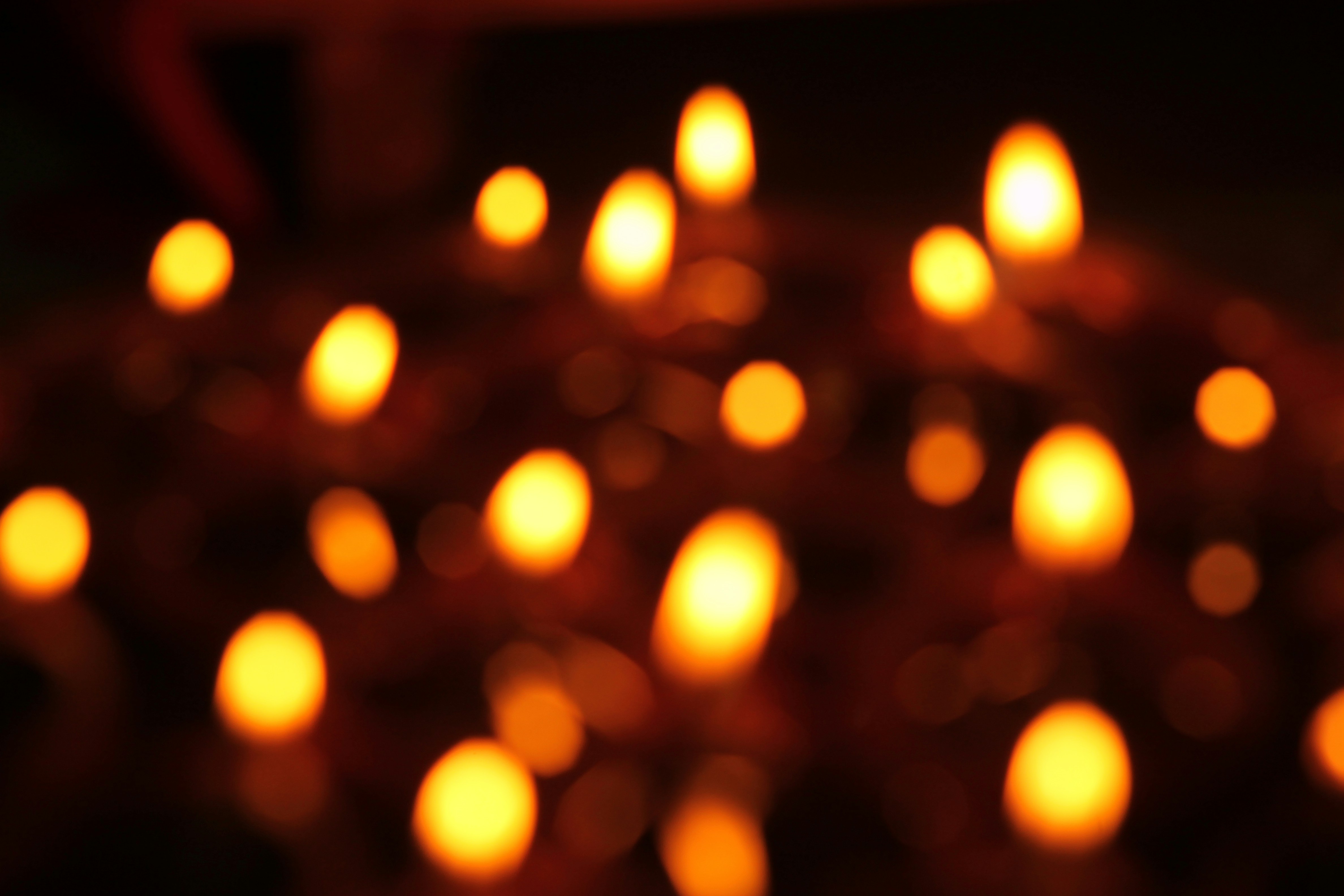 Birthday celebration with candles and wrapped gifts, warm golden bokeh lights, dark atmospheric party setting