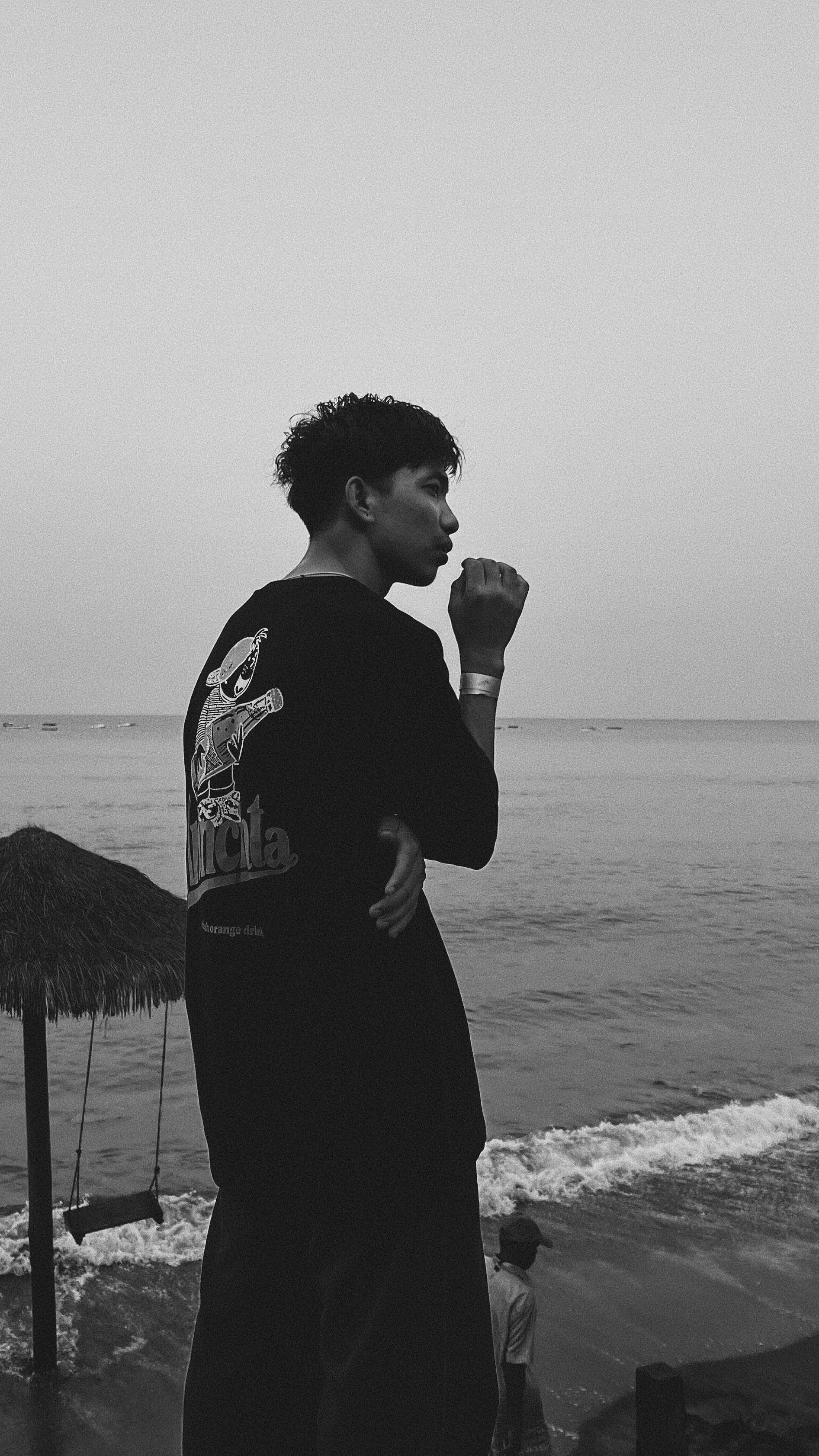 A man standing on a beach next to the ocean