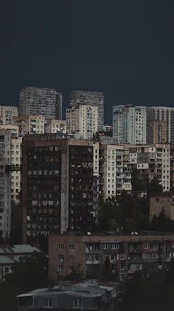 A view of a Tbilisi with old Soviet style buildings under a dark sky