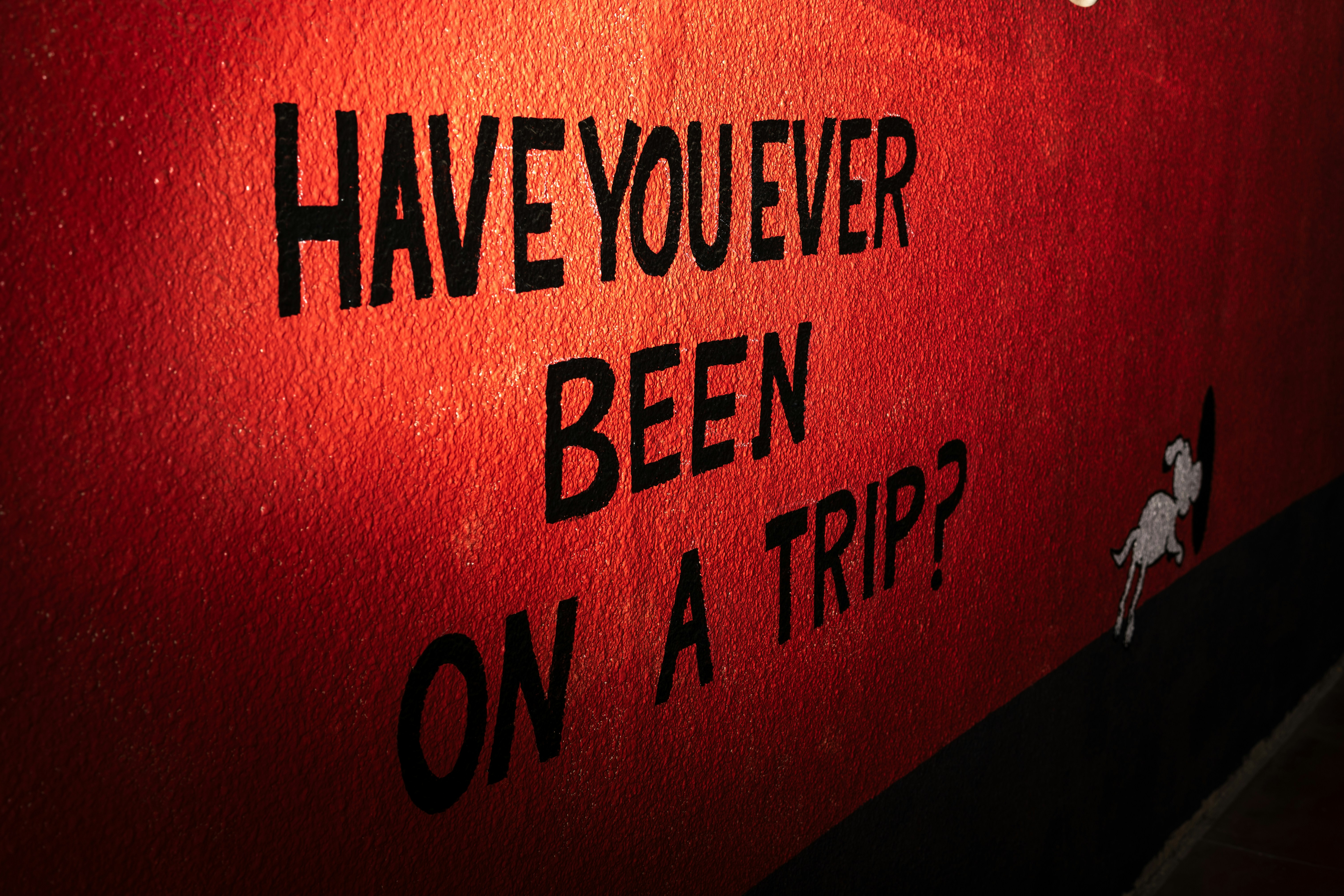 A red sign that says have you ever been on a trip?