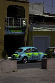 A blue and green car parked in front of a building