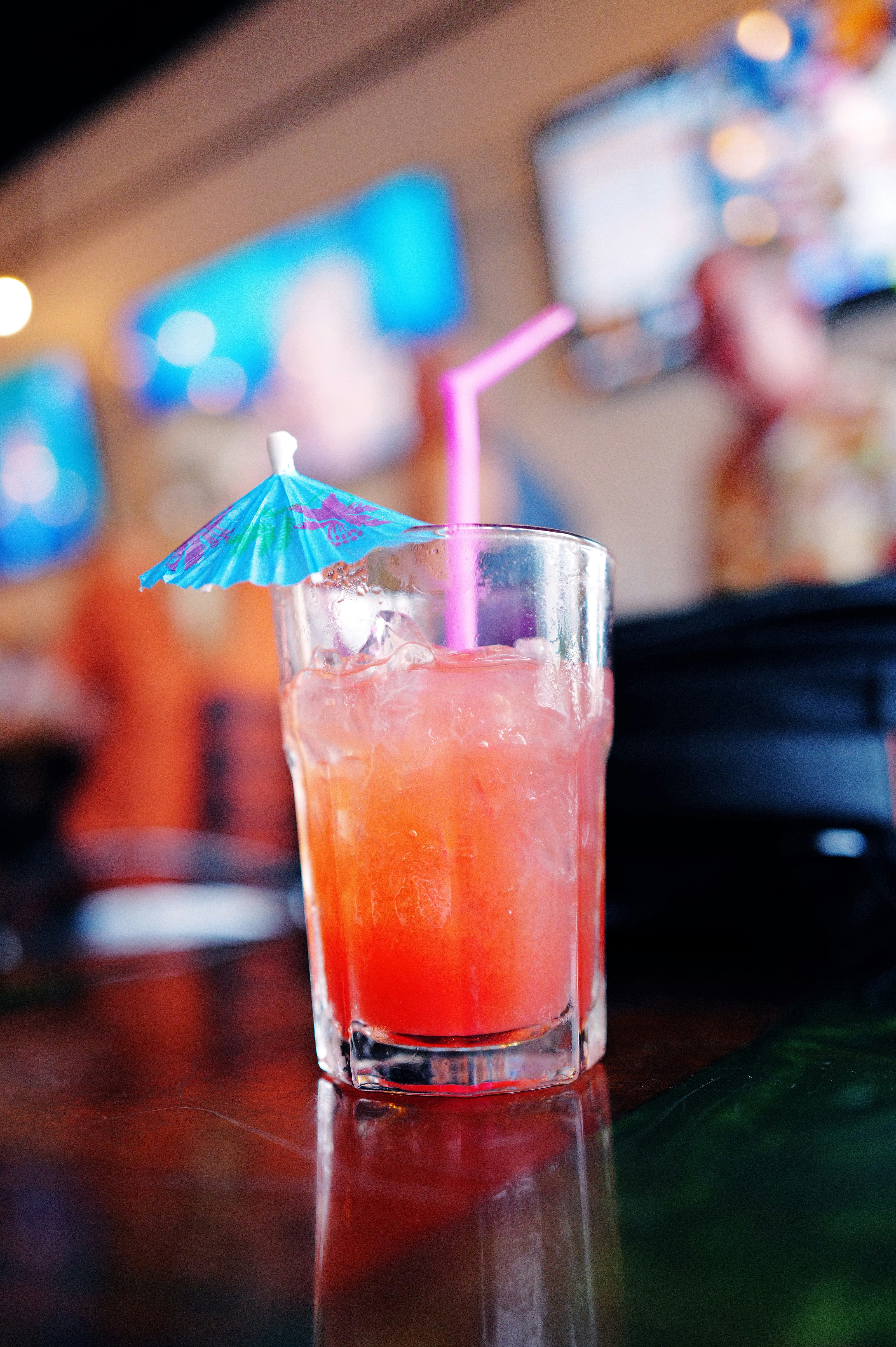 a glass with a drink and an umbrella on a table