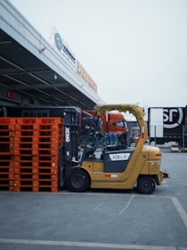 a forklift parked in a parking lot next to orange pallets