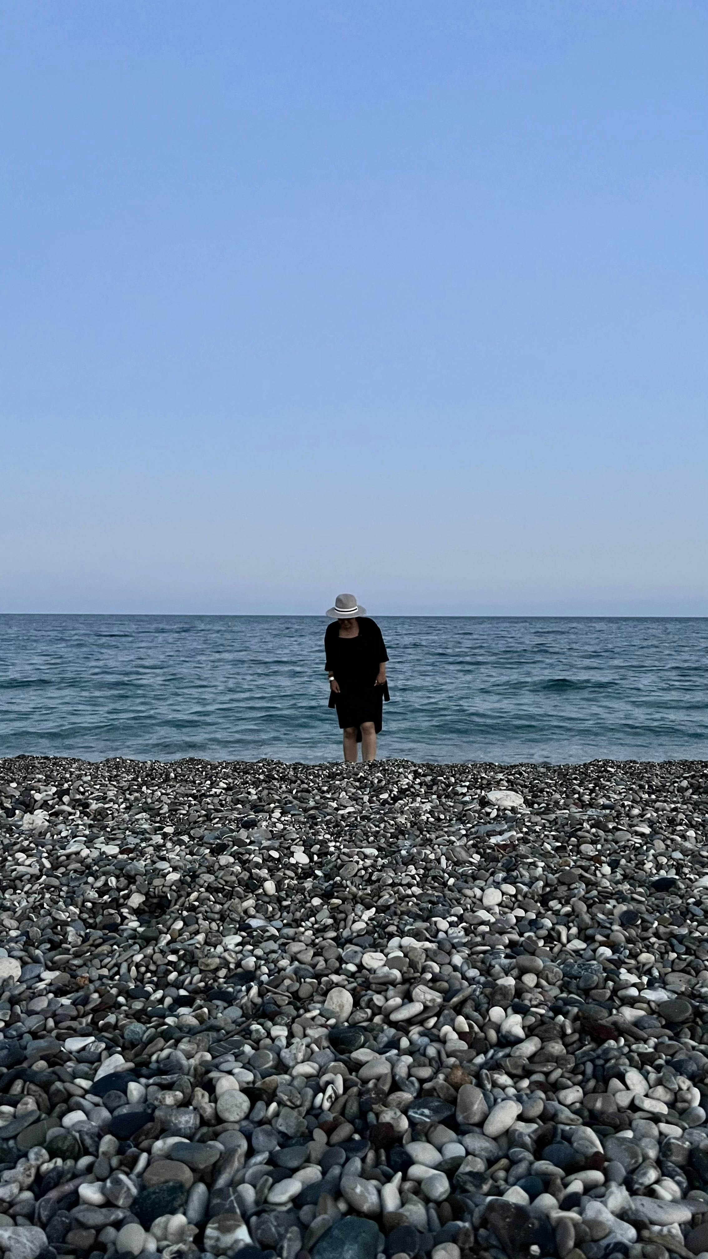 a man standing on a rocky beach next to the ocean