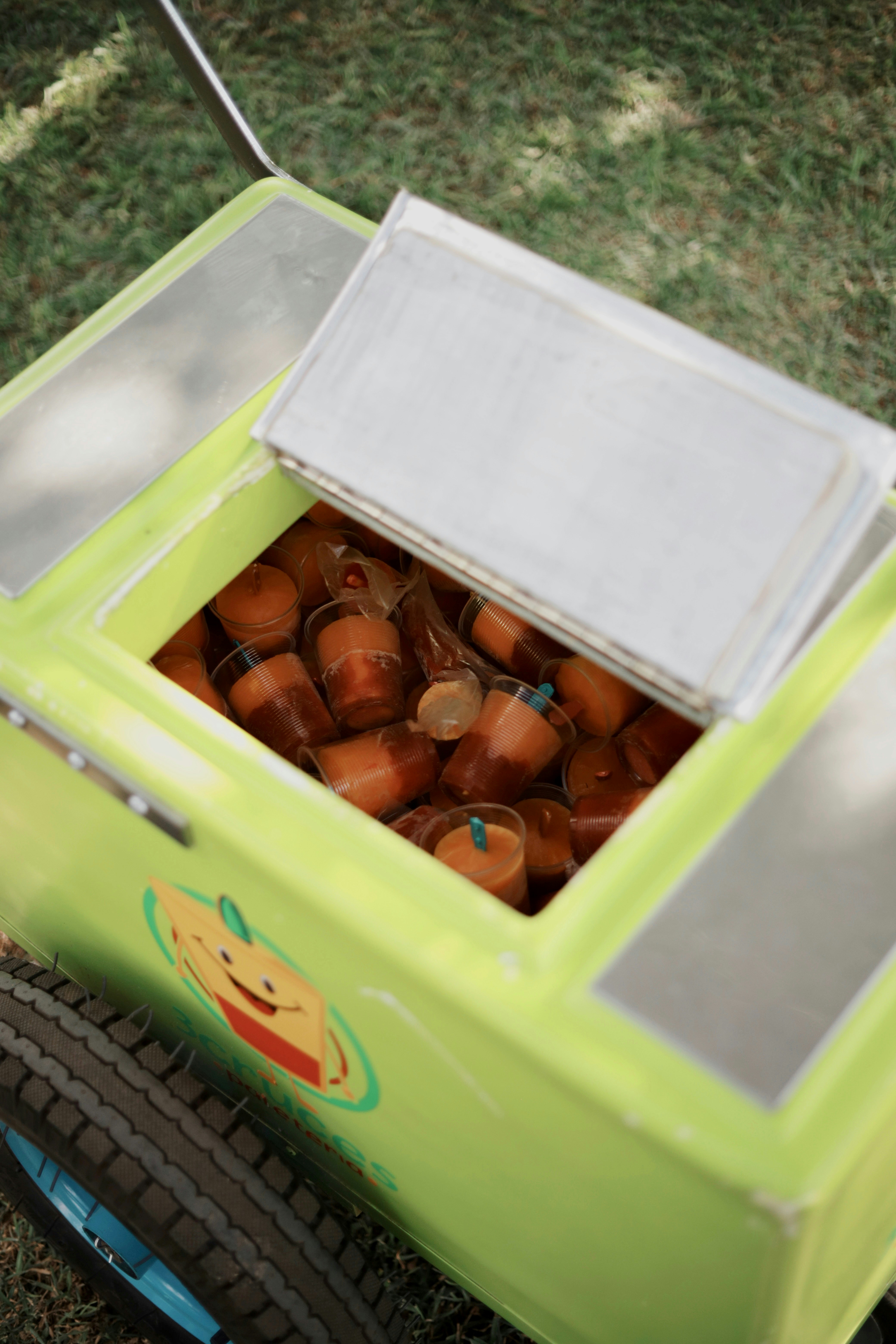 a green toy car filled with lots of oranges