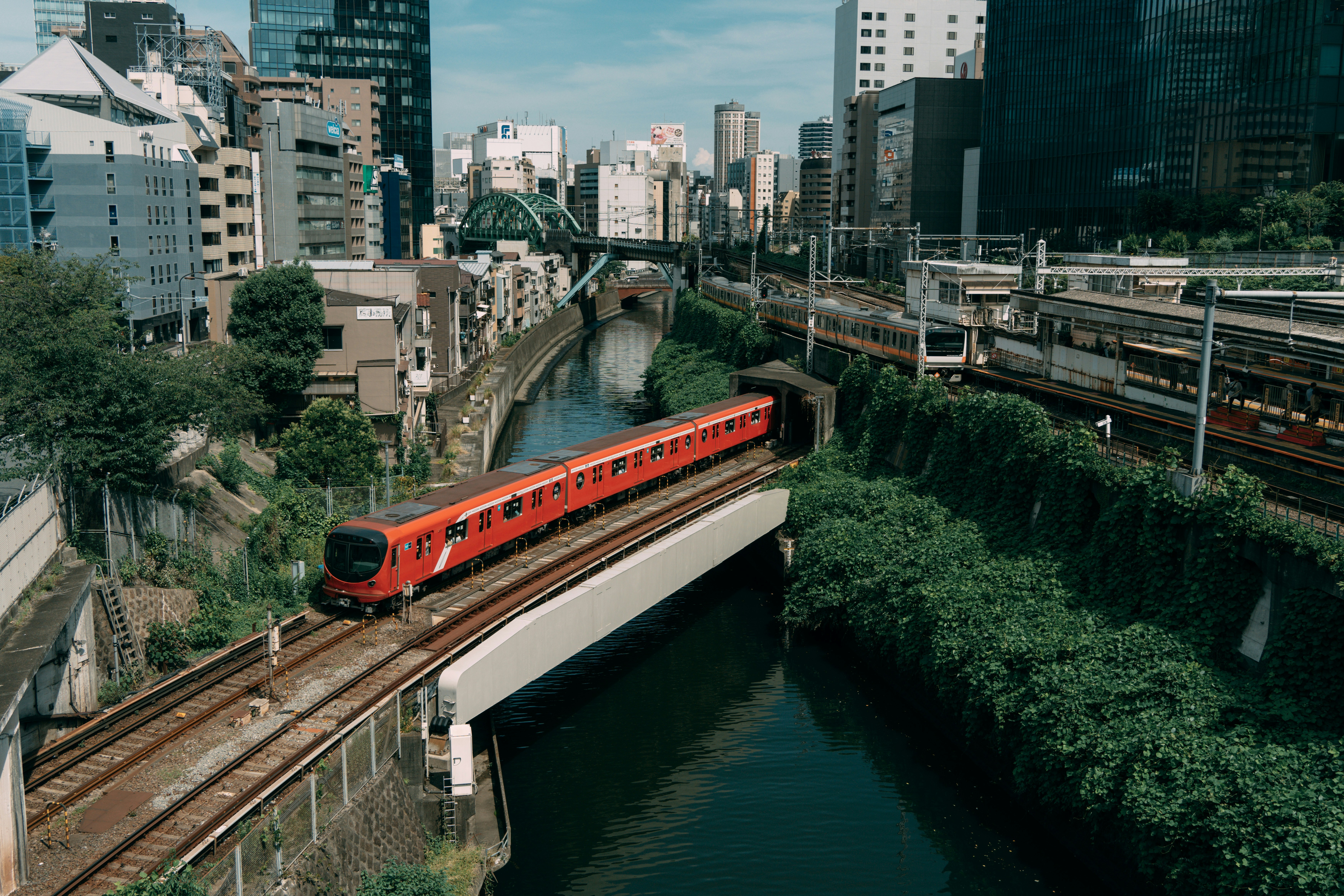 a red train traveling over a bridge over a river
