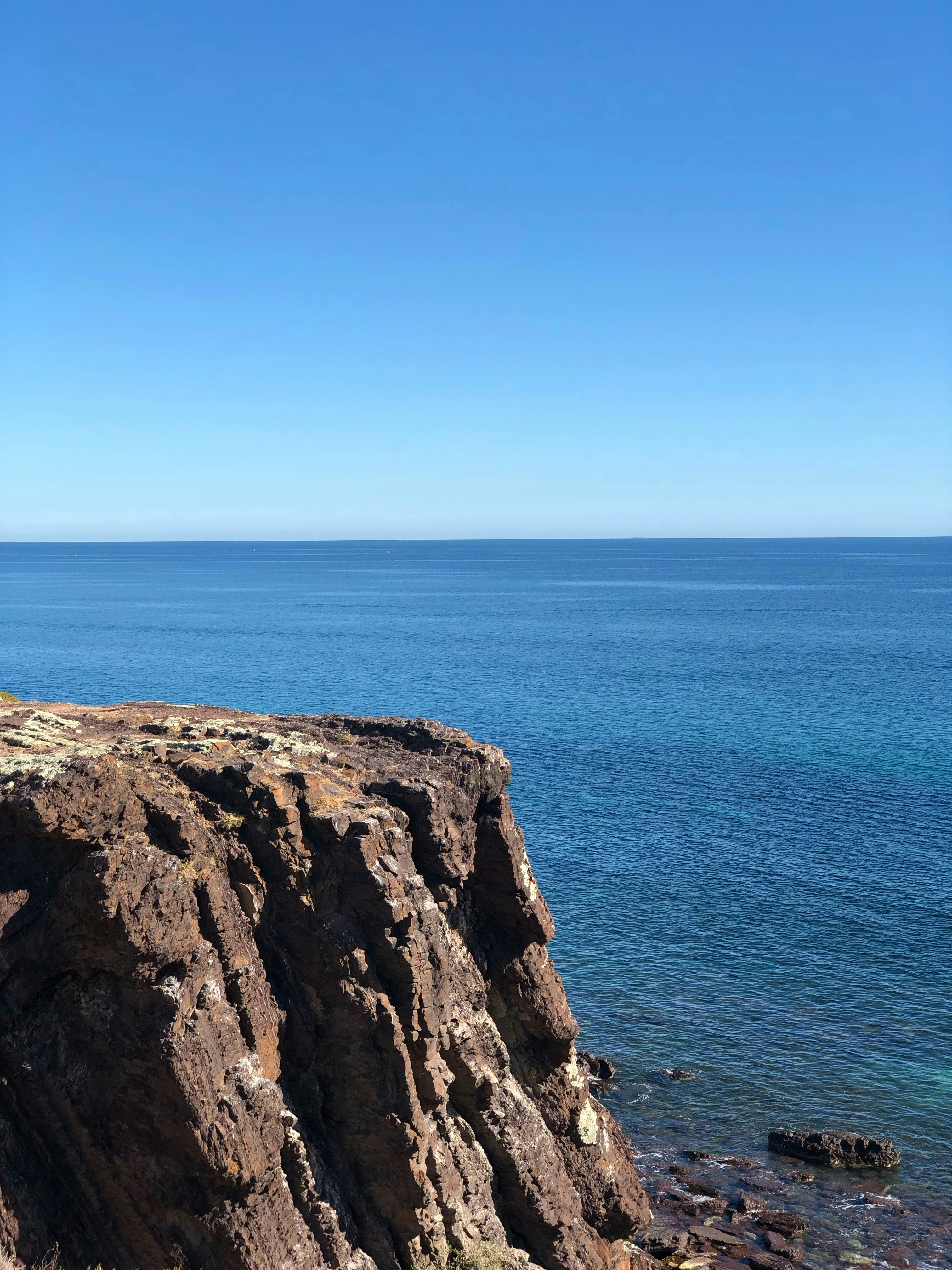 Un banco sentado en el borde de un acantilado con vistas al océano