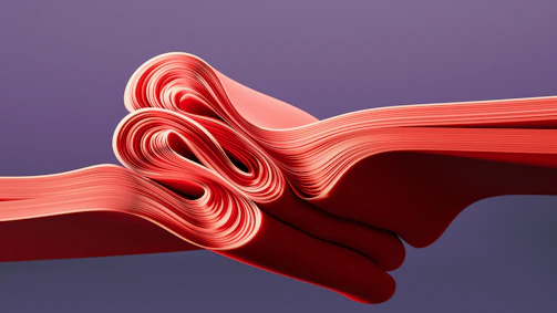 A close up of a red ribbon on a purple background
