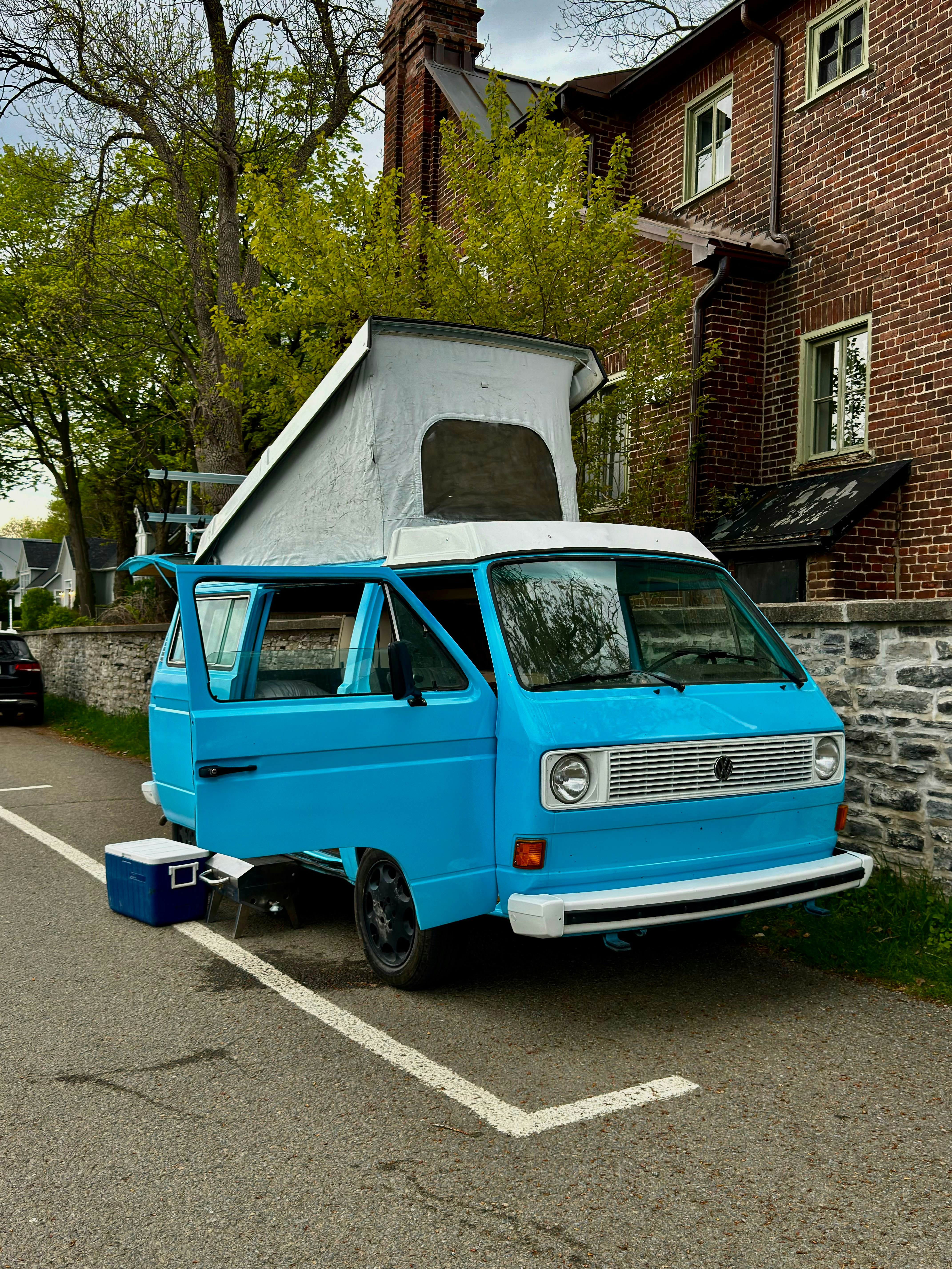a blue van parked in a parking lot next to a brick building