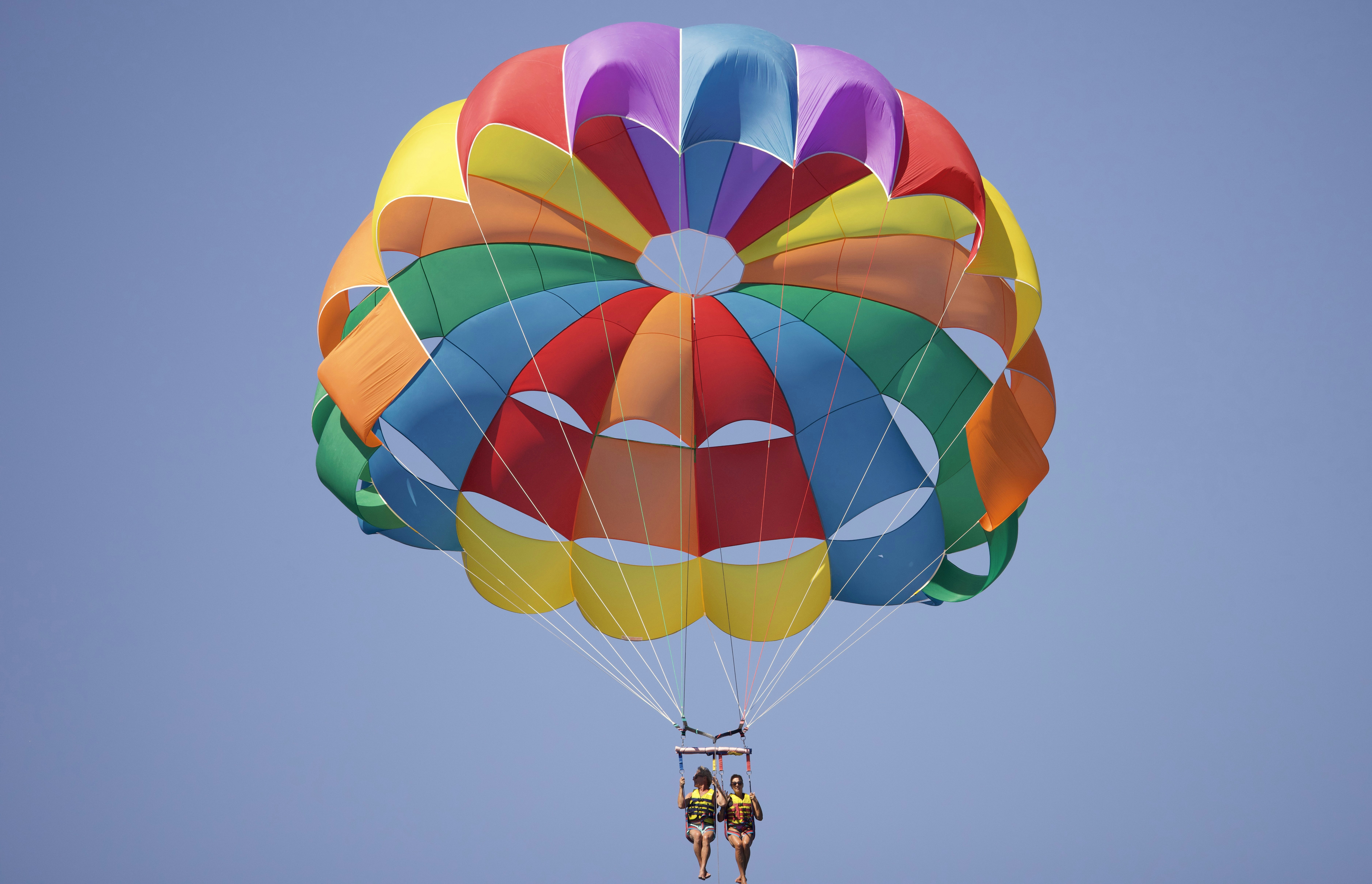 A person is parasailing in the blue sky