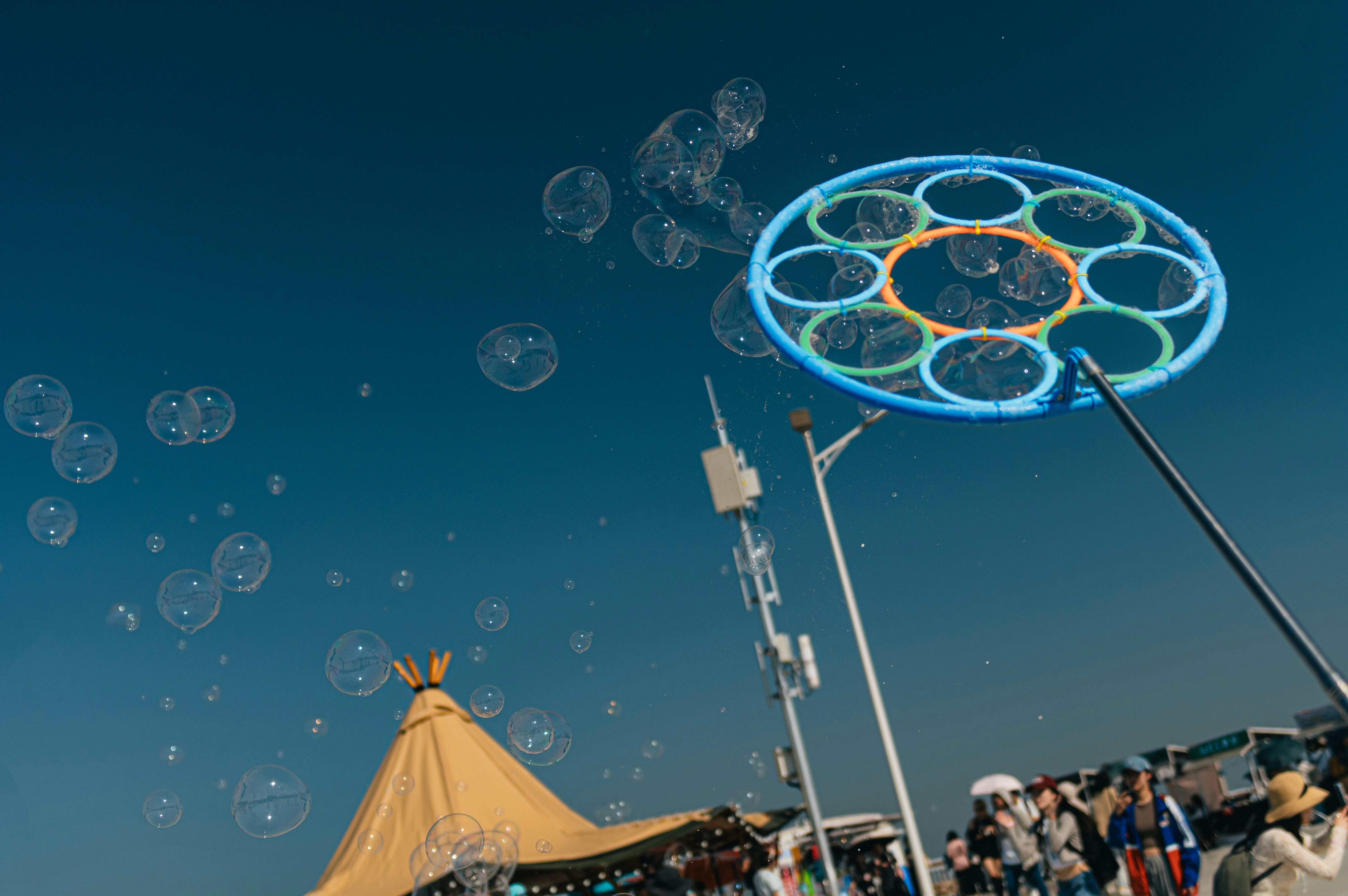 A group of people standing around a tent with bubbles in the air
